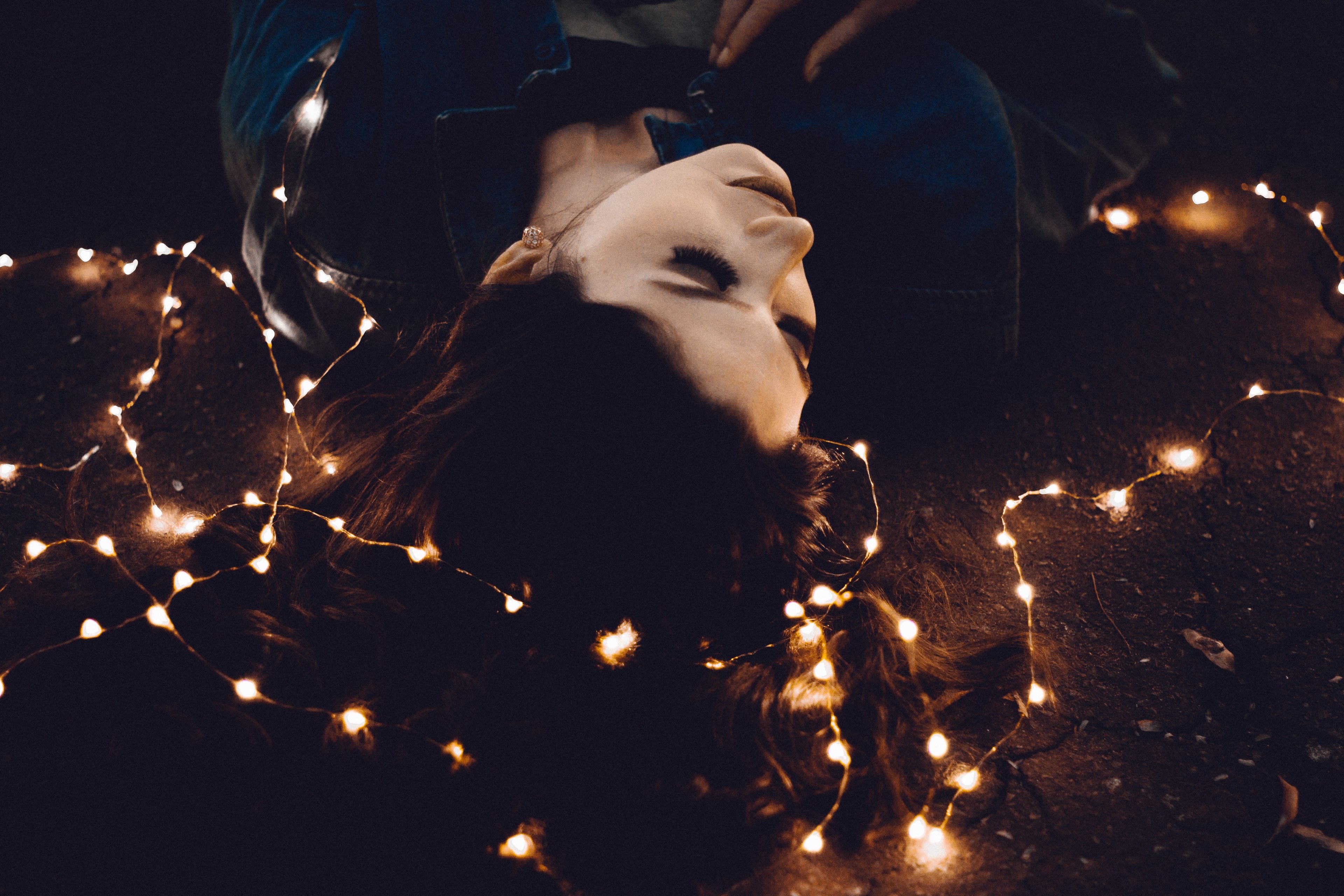 a woman lays her head on a floor covered in string lights, woman laying on string lights 4k, HD Wallpaper