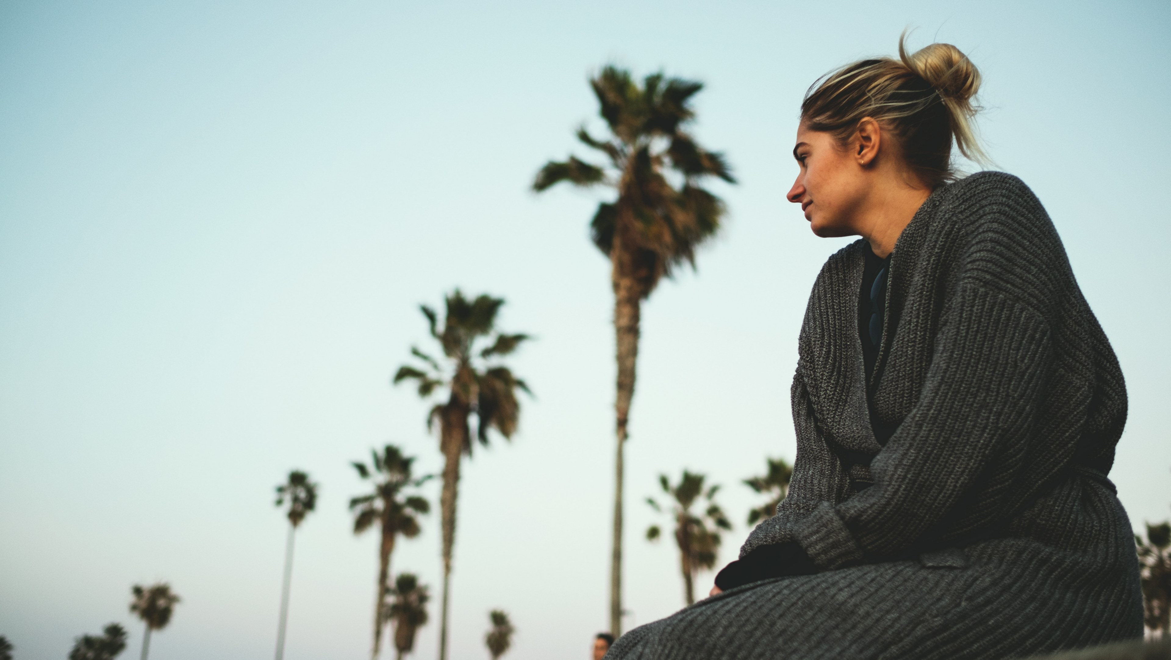 woman in knitted cardigan sitting by the palm tree boulevard at ocean beach pier, california dreaming 4k, HD Wallpaper