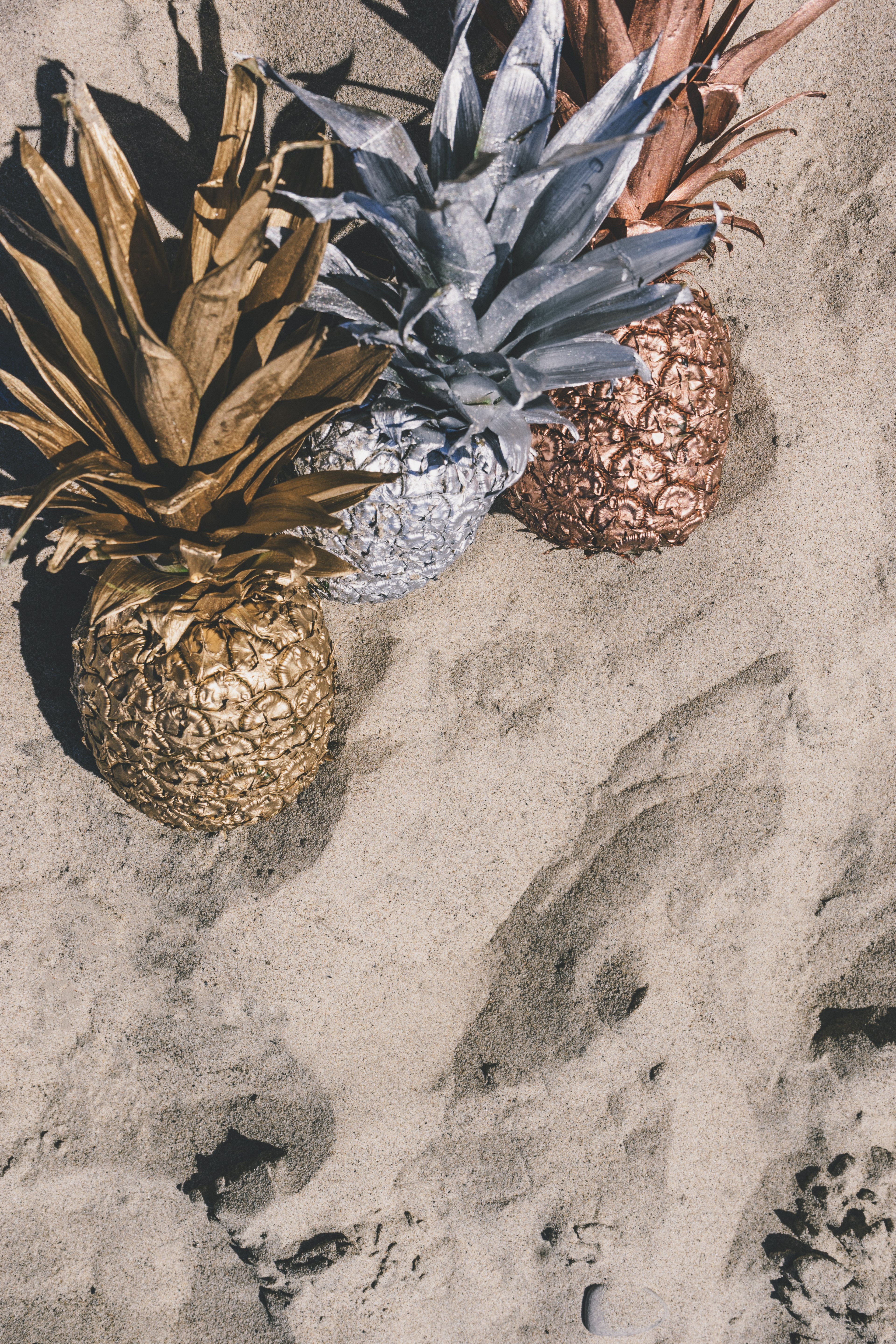 three pineapples in varying colors in the sand, _pineapples and sand 4k, Phone HD Wallpaper