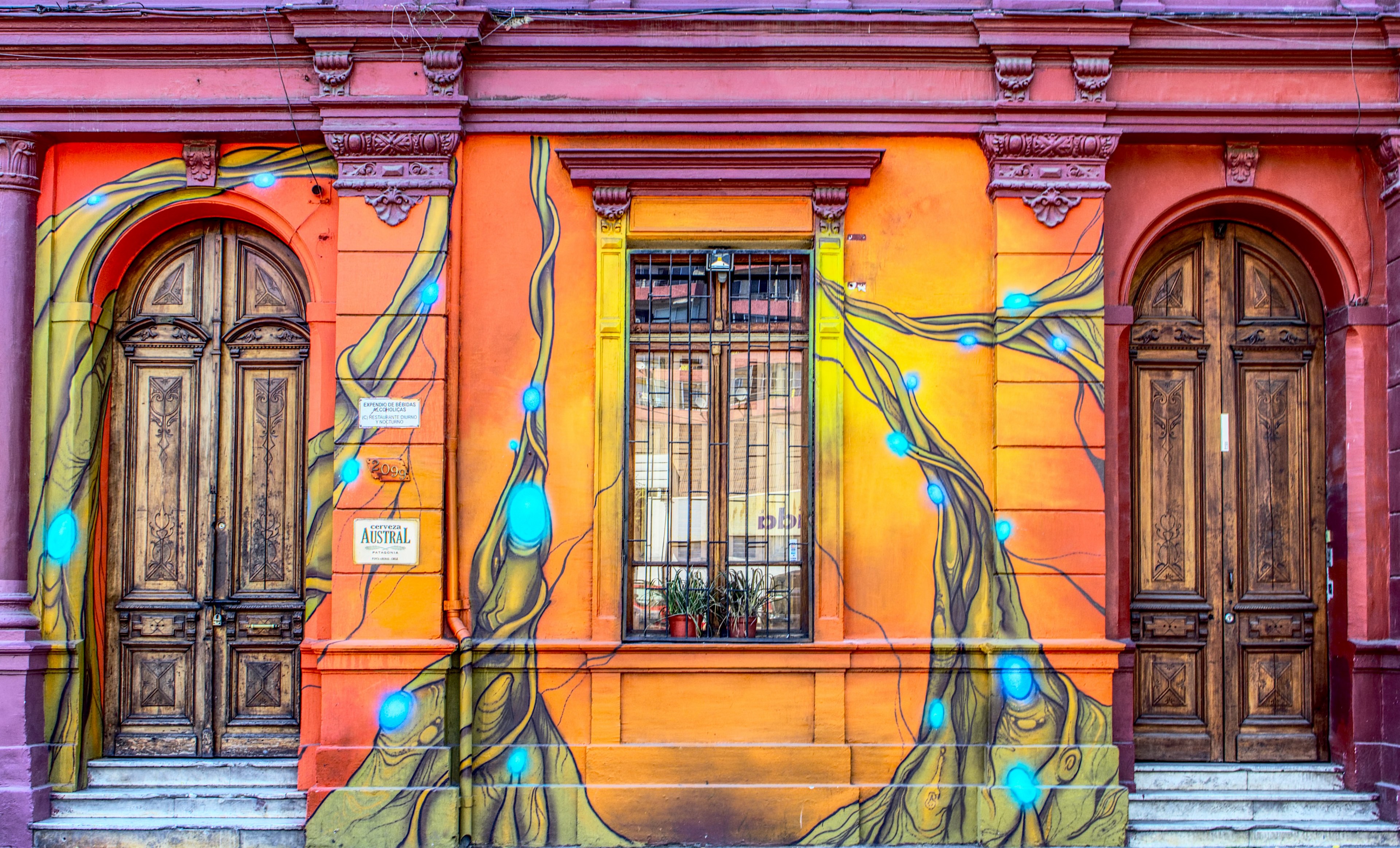 colorful sunburst wall art on building wall with windows and wooden doors santiago, facade 4k, HD Wallpaper