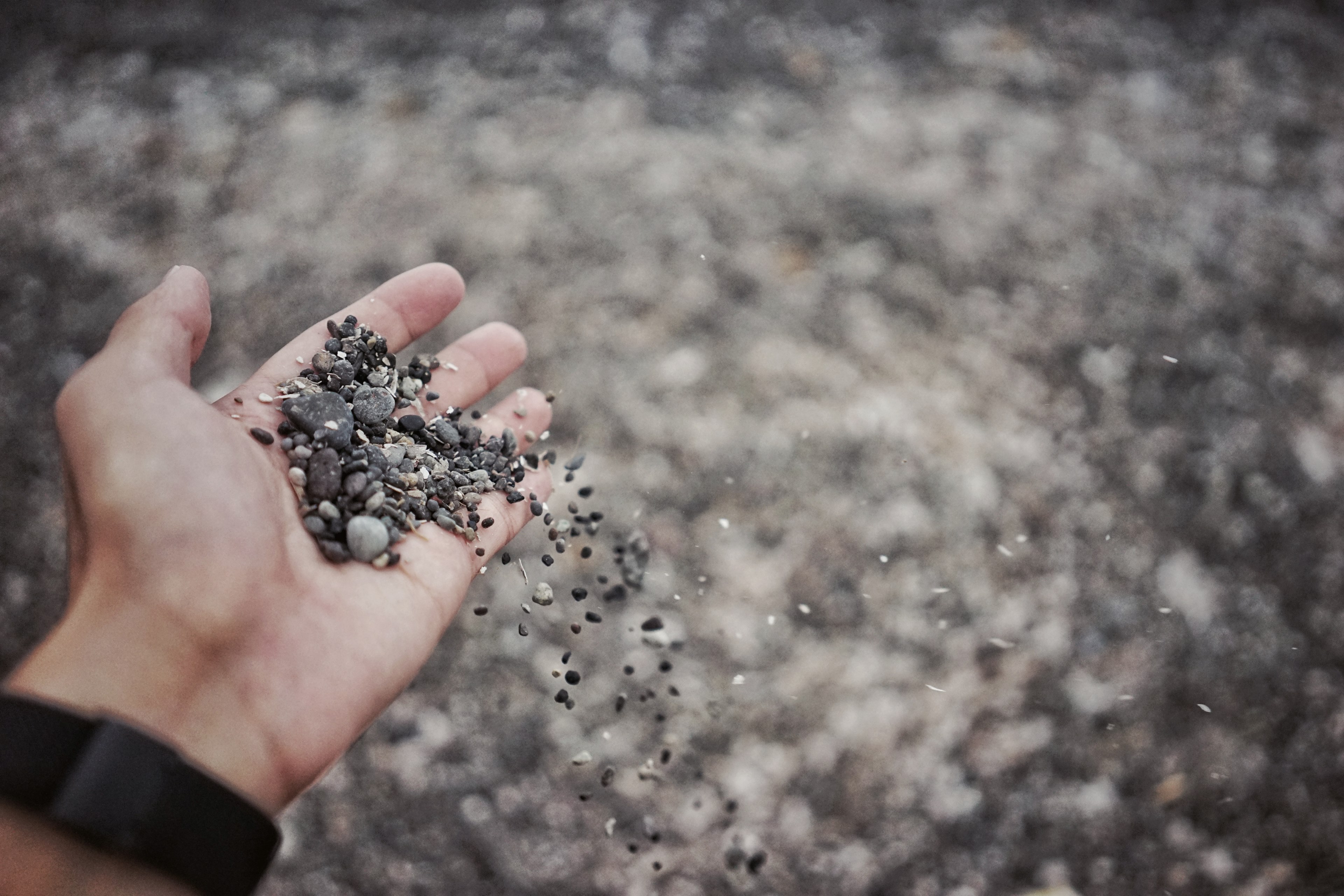 a person wearing a watch holding a bunch of gravel in their hand, gravel 4k, HD Wallpaper