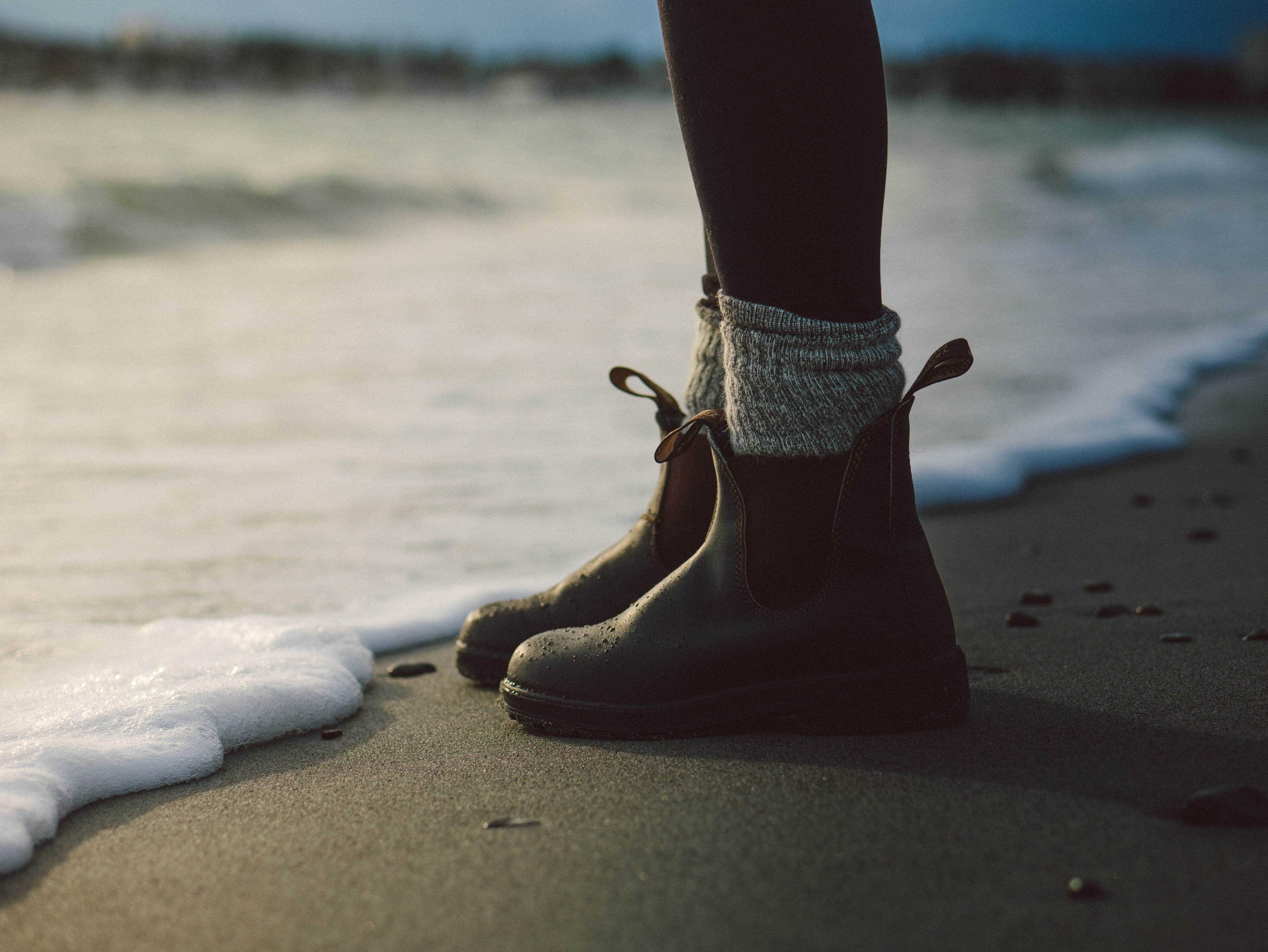 a person in boots stands on the sand near the shore as the waters foam movies in, boots on the beach 4k, HD Wallpaper