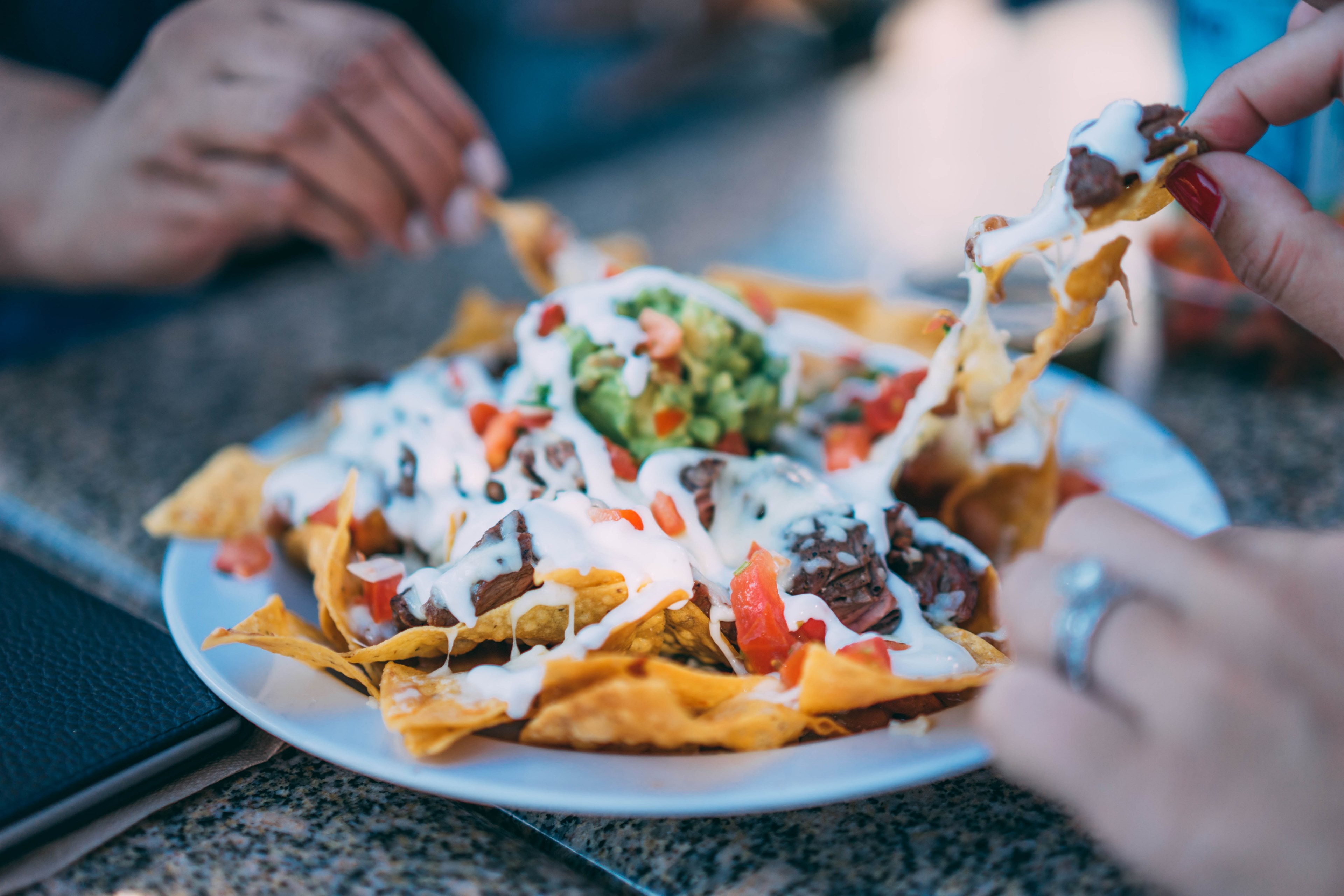 people sharing a plate of mexican nachos with vegetables and meat, eating nachos 4k, HD Wallpaper