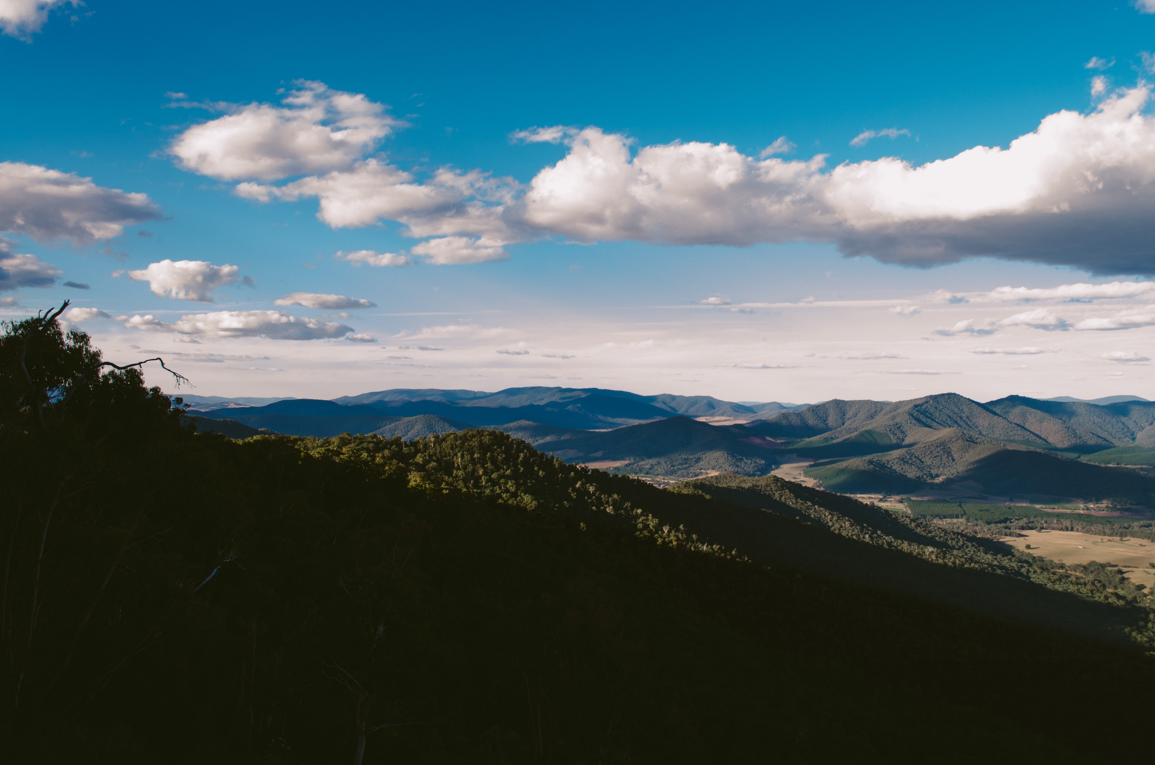 a mountainous landscape under fluffy white clouds, natural shadows 4k, HD Wallpaper
