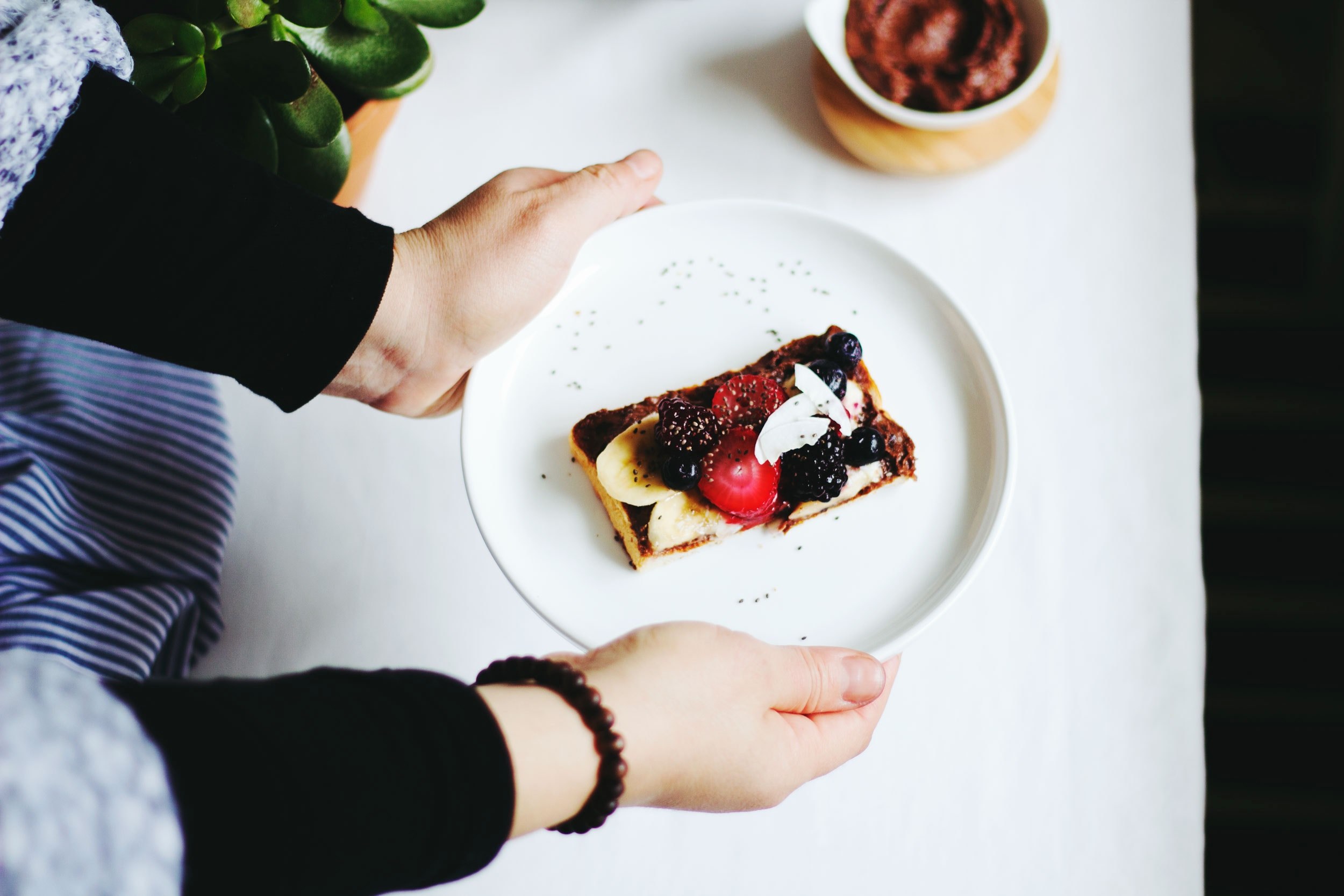 a person holding a plate of toast with jam berries bananas and almonds, breakfast toast 4k, HD Wallpaper