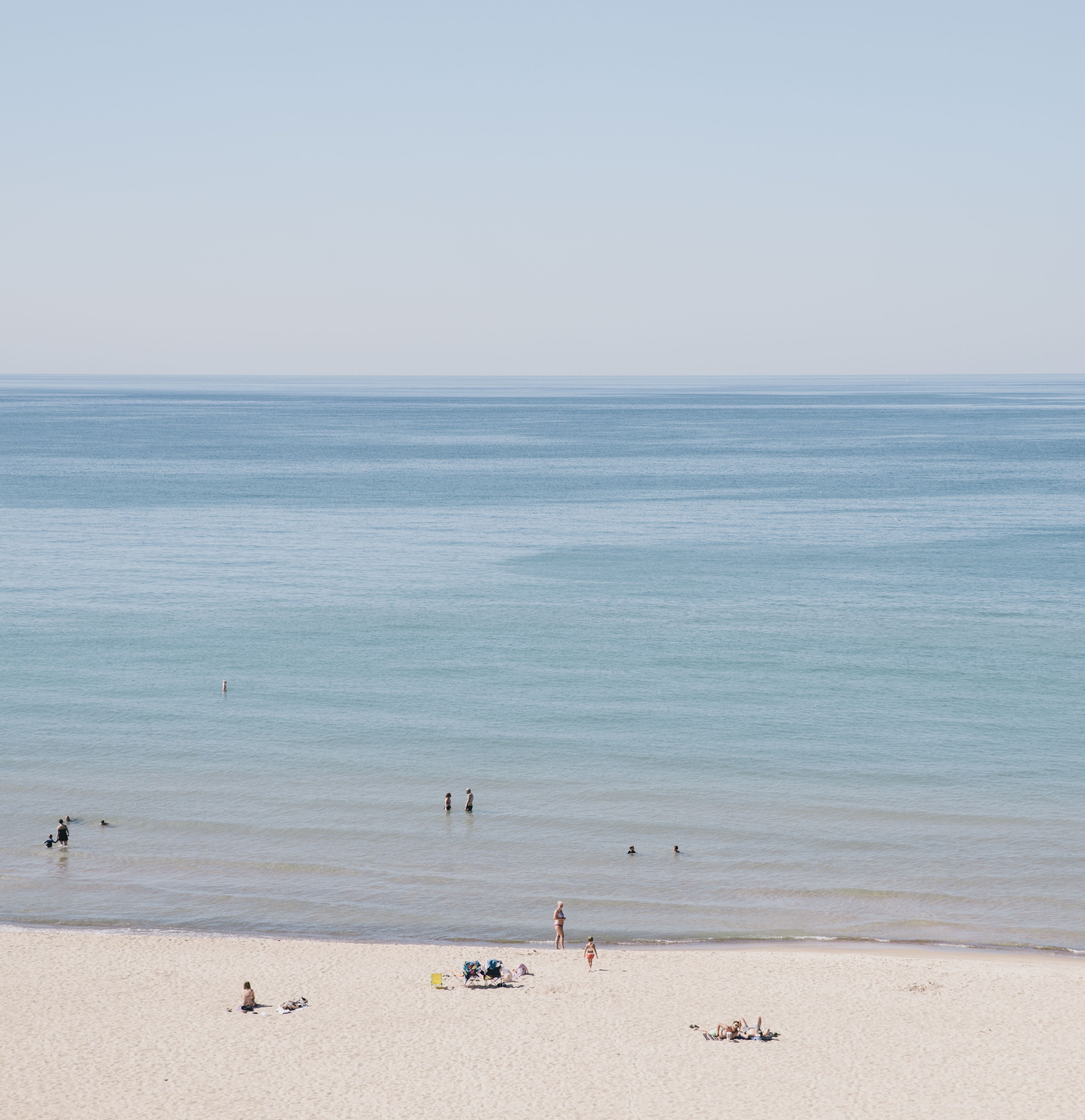 view of the swimmers on the sandy beach of the calm ocean, sand beach by the calm ocean 4k, Phone HD Wallpaper