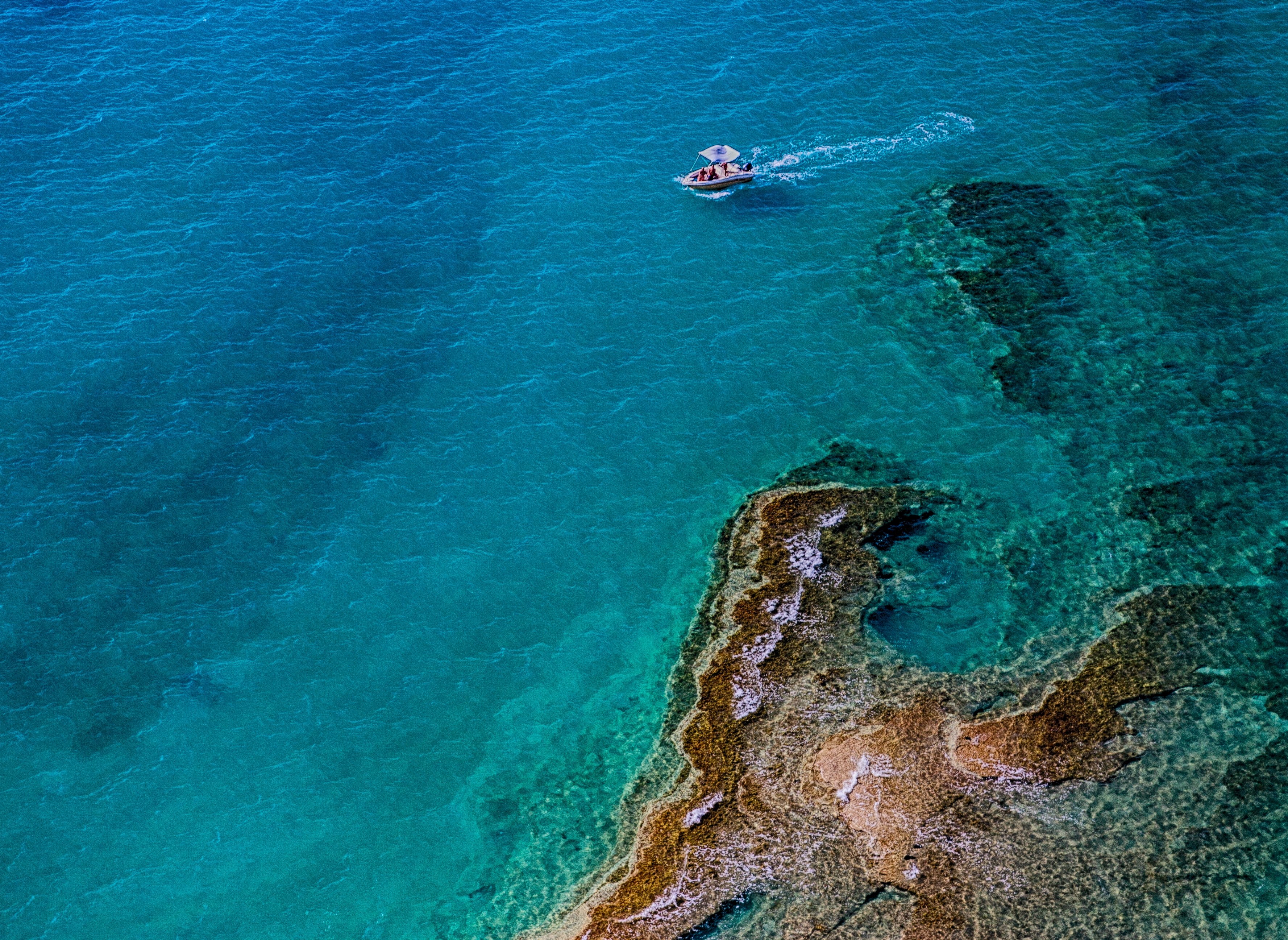 a small motorboat near a large reef in the turquoise sea, on a motorboat near a reef 4k, HD Wallpaper