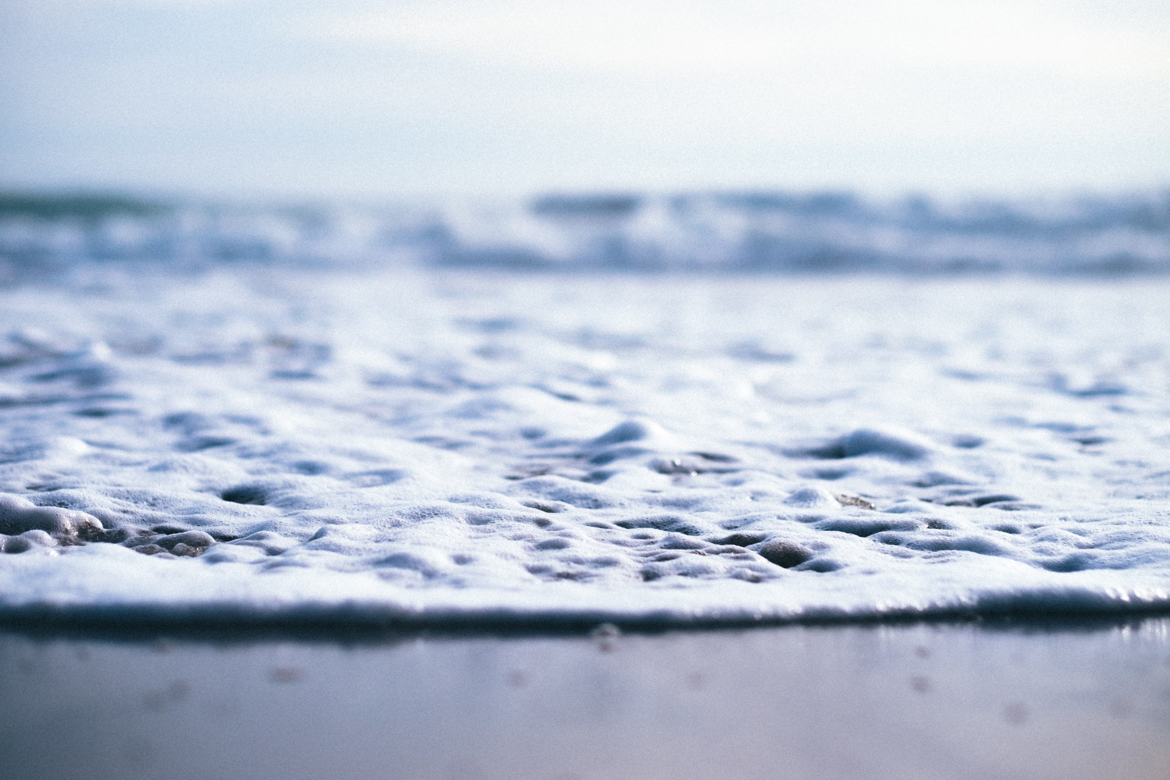 closeup shot of the sand and sea as the water foams up taken in sunset state beach, sea foam 4k, HD Wallpaper