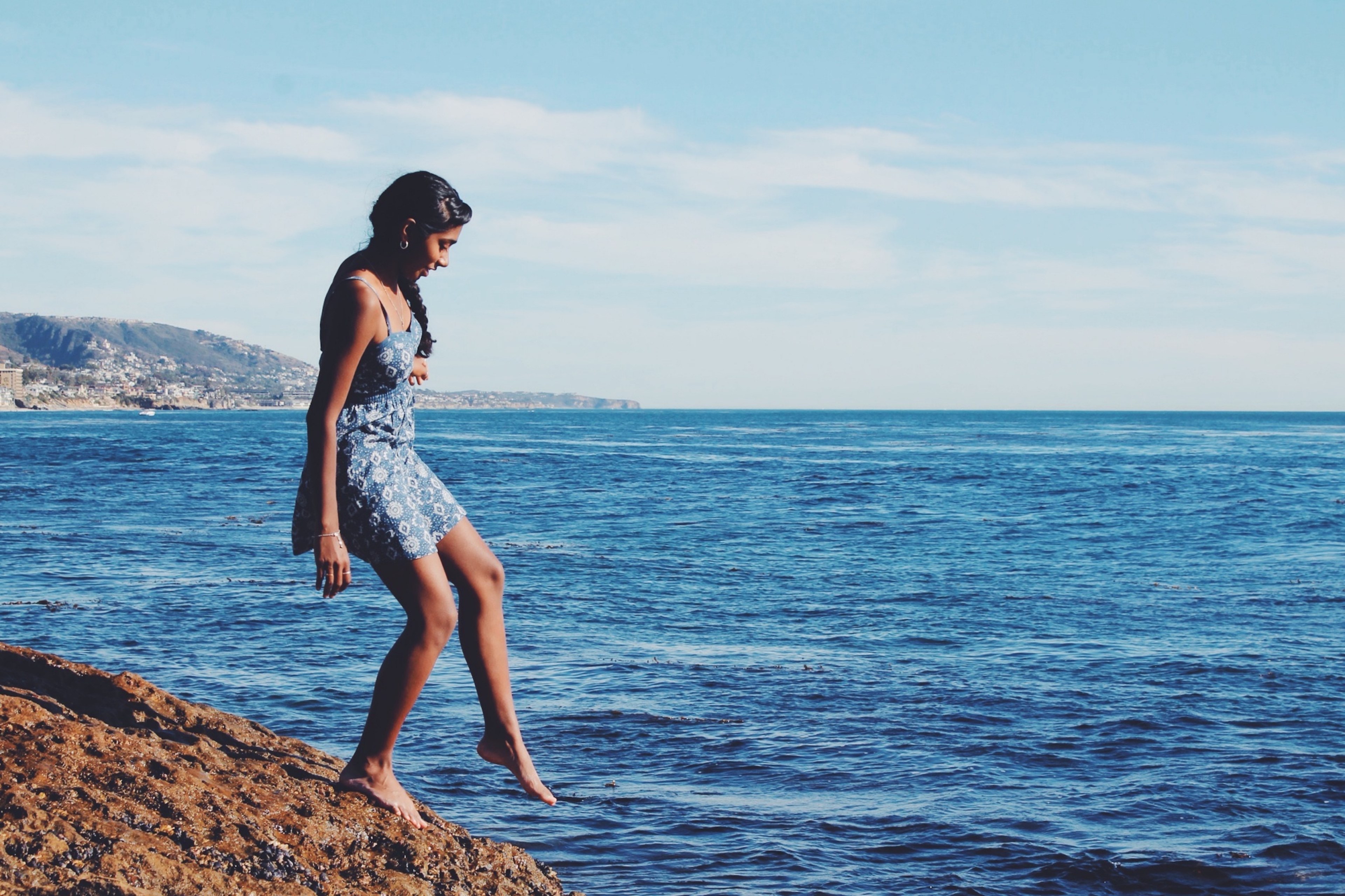 a girl wearing a summer dress dipping her foot into the ocean, touching water with her foot 4k, HD Wallpaper