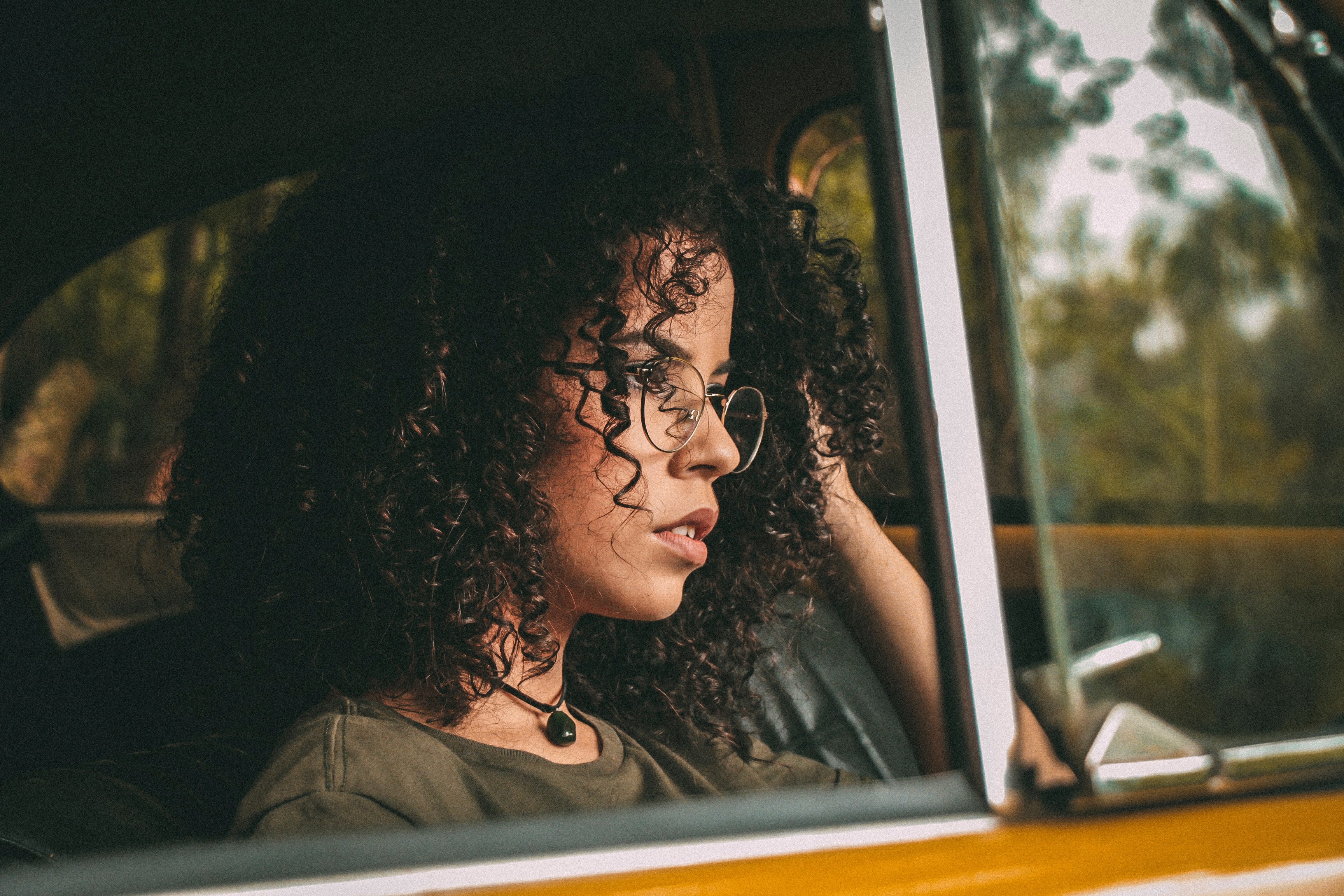 woman with curly hair and vintage glasses staring out a car window, looking out the car window 4k, HD Wallpaper