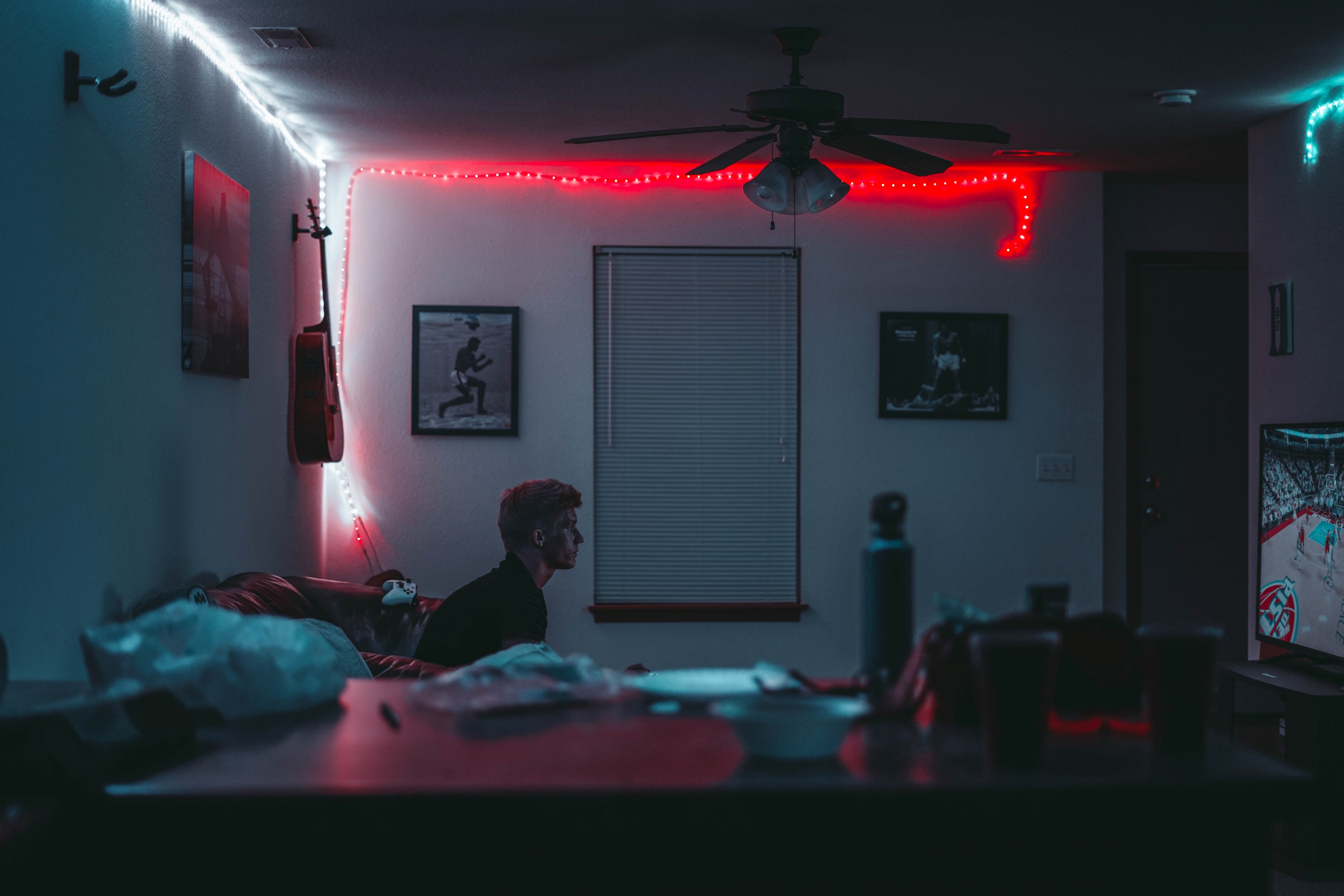 a young man sitting on a leather sofa in a dim room and watching television, 2k life 4k, HD Wallpaper