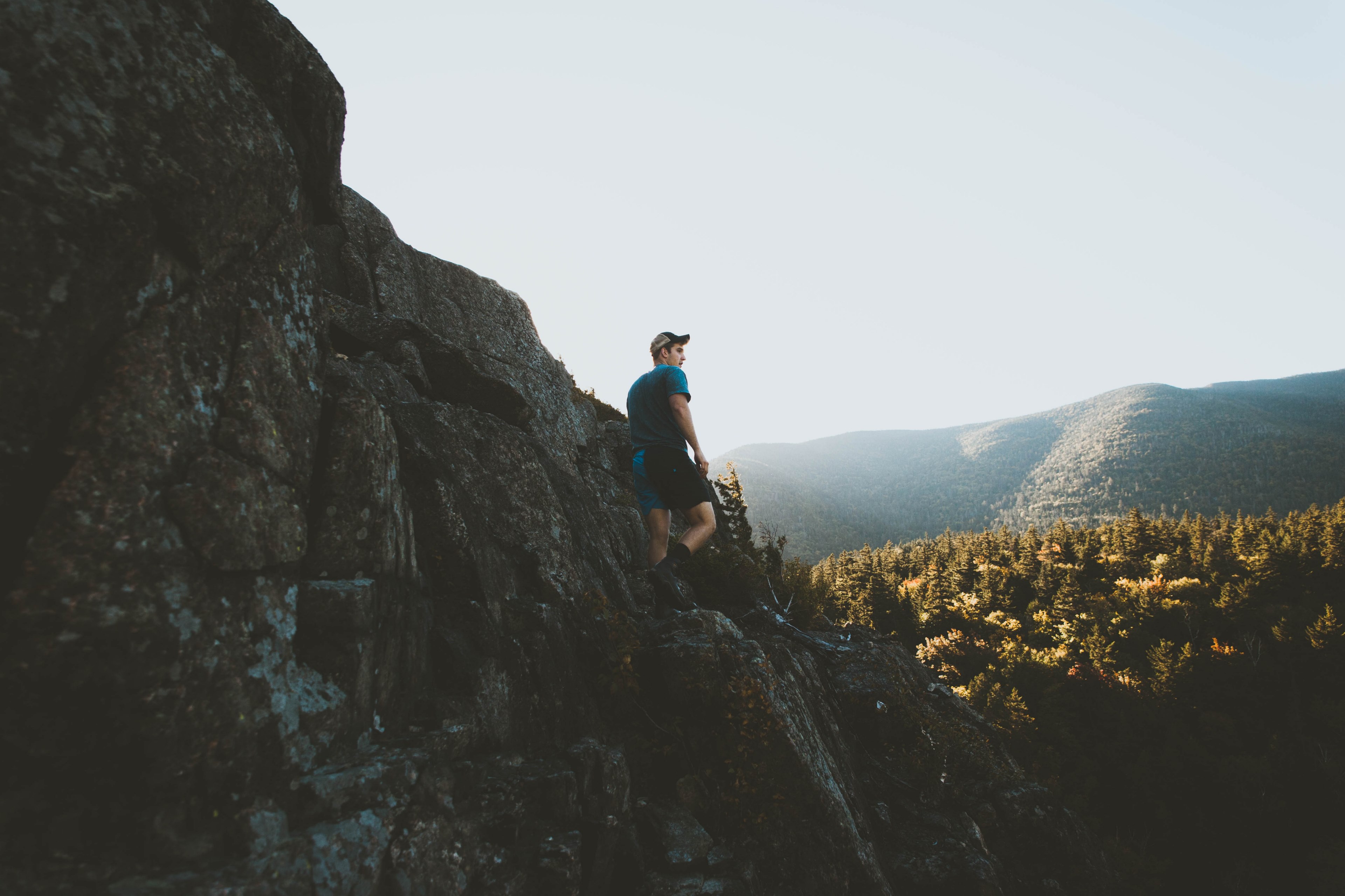 a young man in a cap on a jagged rock formation in a morning, hiking on rugged rocks 4k, HD Wallpaper