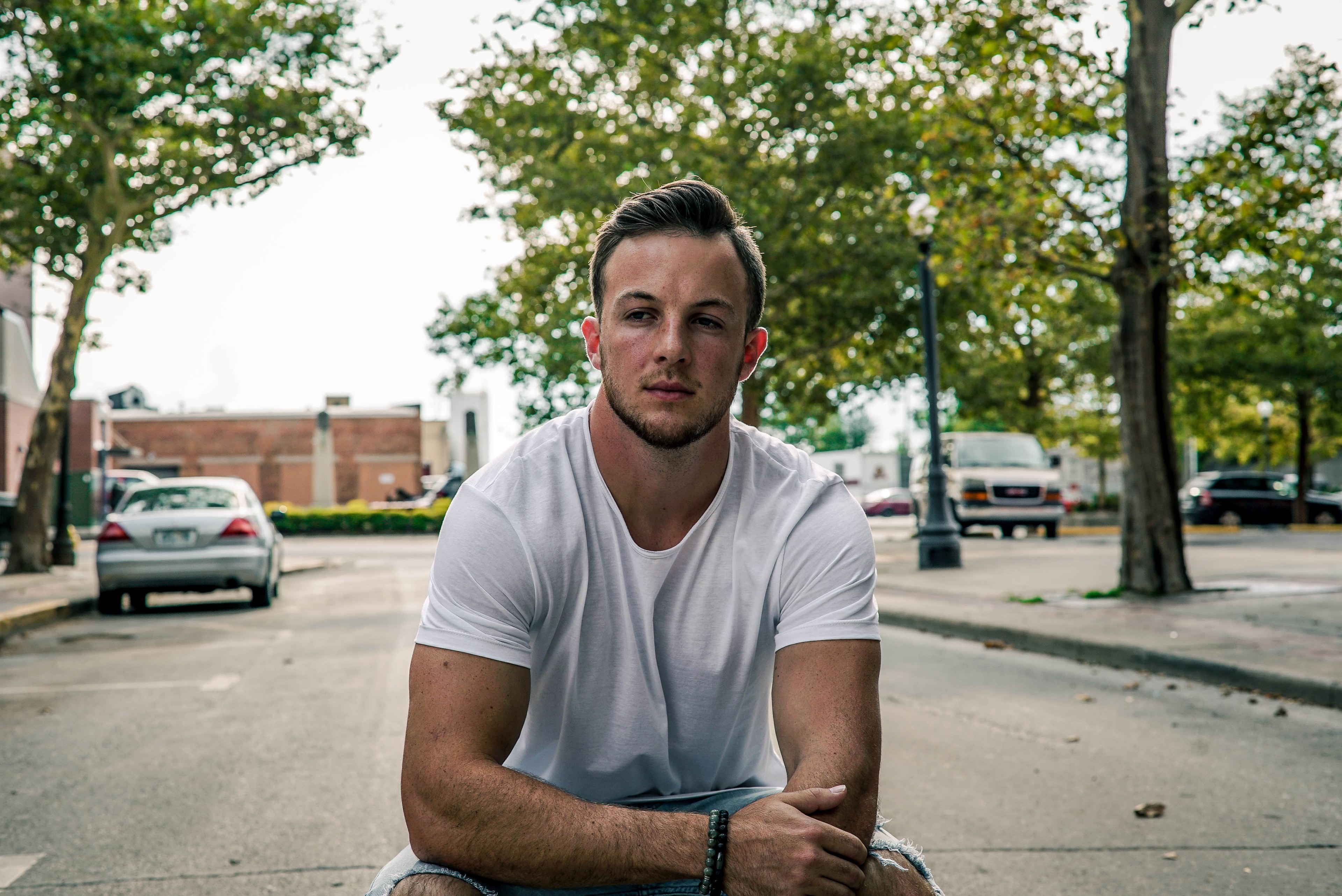young man in a white shirt crouches contemplating in the street, outlined 4k, HD Wallpaper