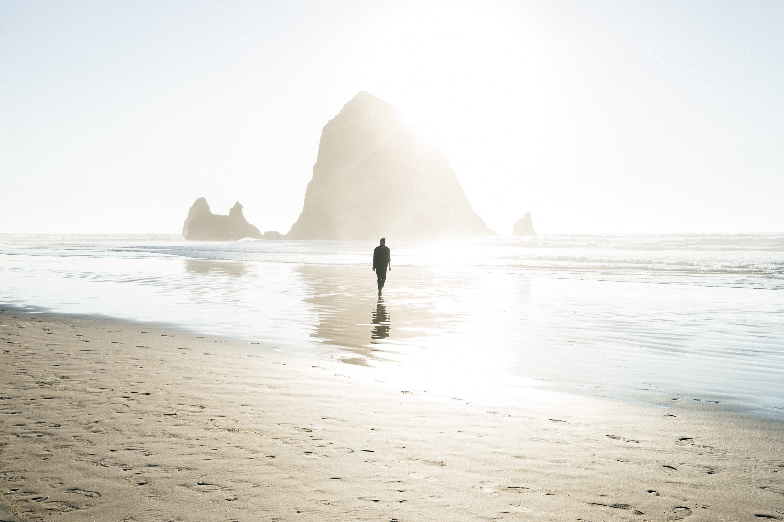 a silhouette of a man walking through the shallow water on a sandy beach, lone man on a wet beach 4k, HD Wallpaper