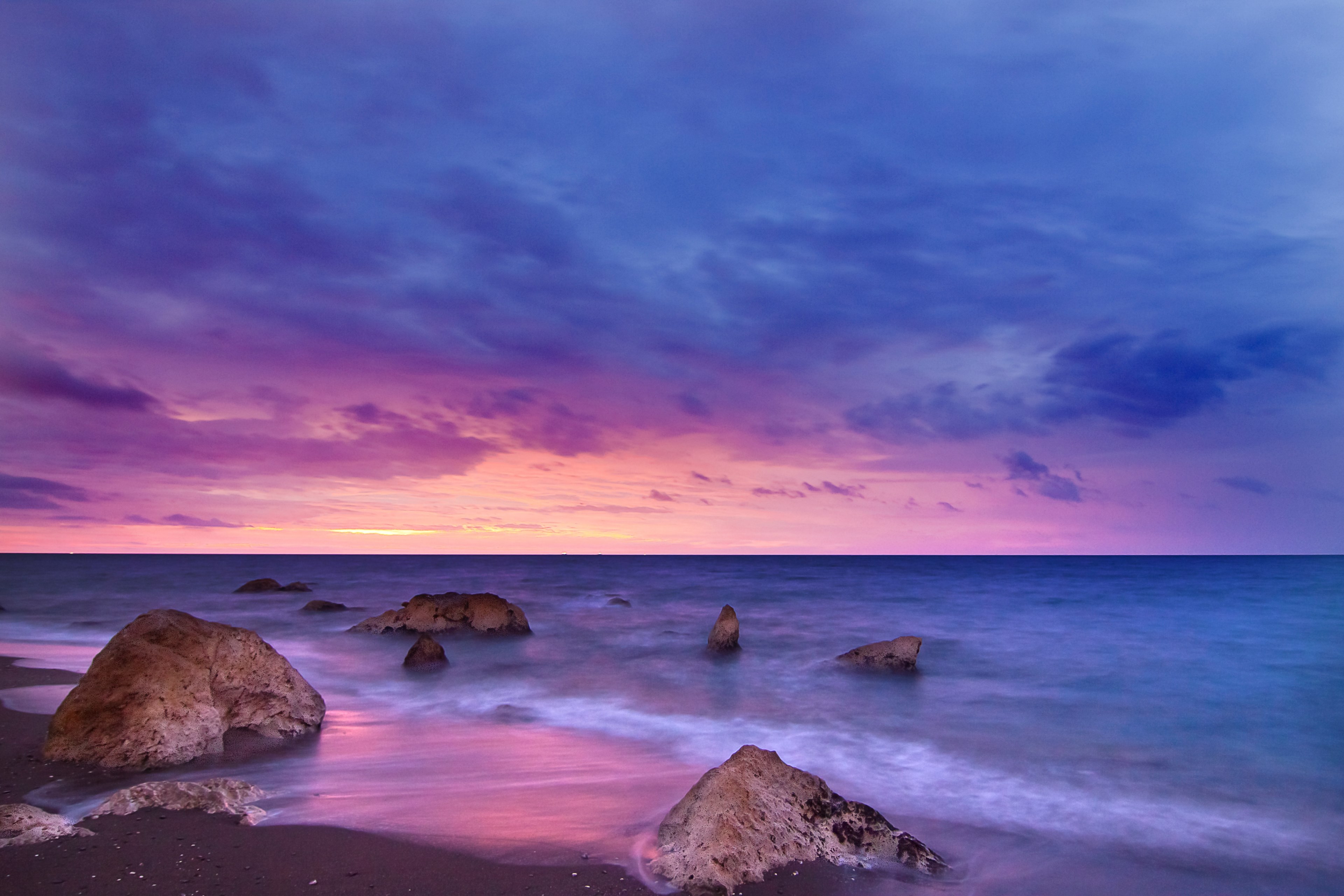 rocks sit in a calm sea at twilight as the sunset creates a pink purple and navy sky at playa del penn del cuervo, playa del penn del cuervo sunset_ 4k, HD Wallpaper