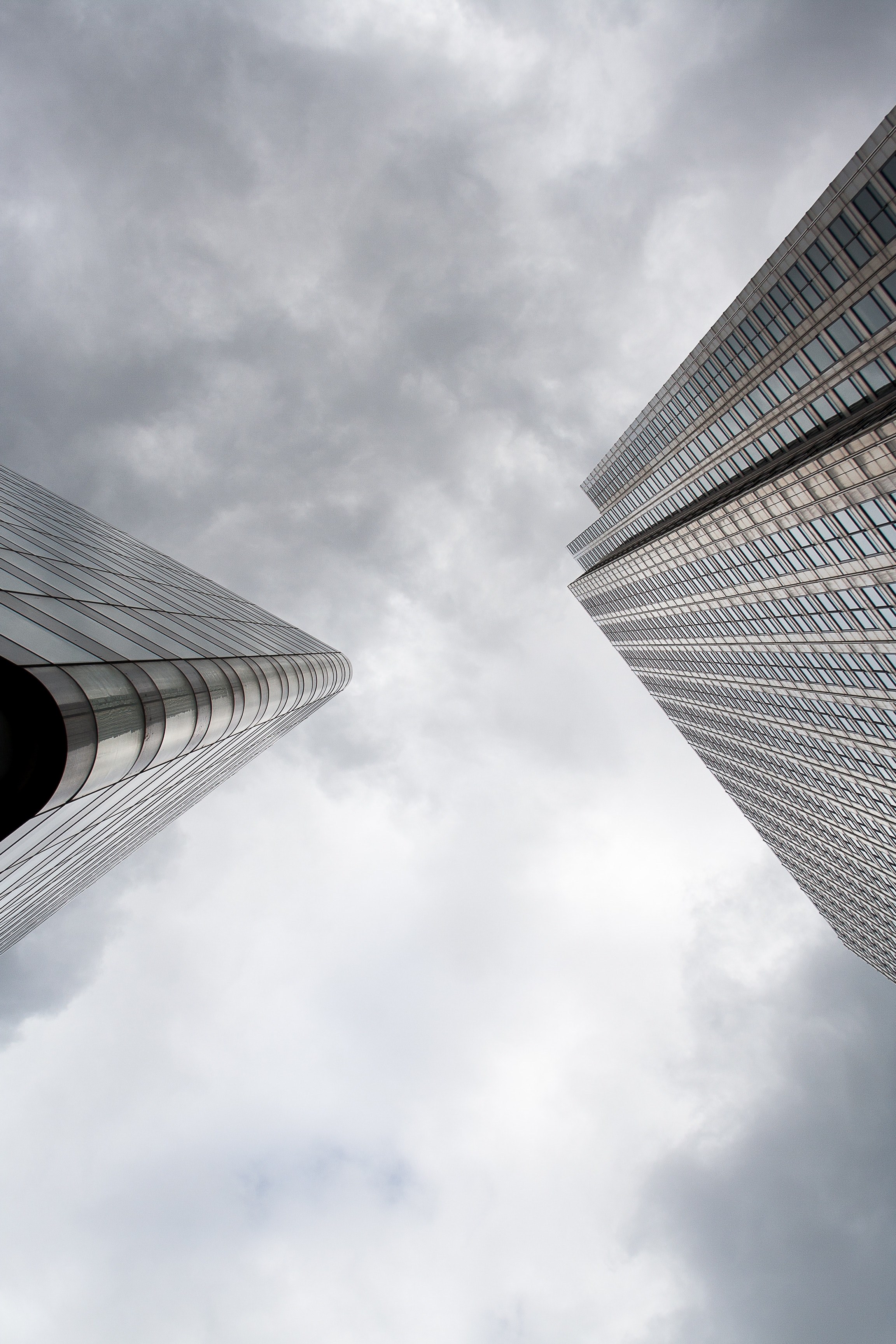 a low angle shot of the corners of two skyscrapers against a cloudy sky, skyscraper edges under clouds 4k, Phone HD Wallpaper