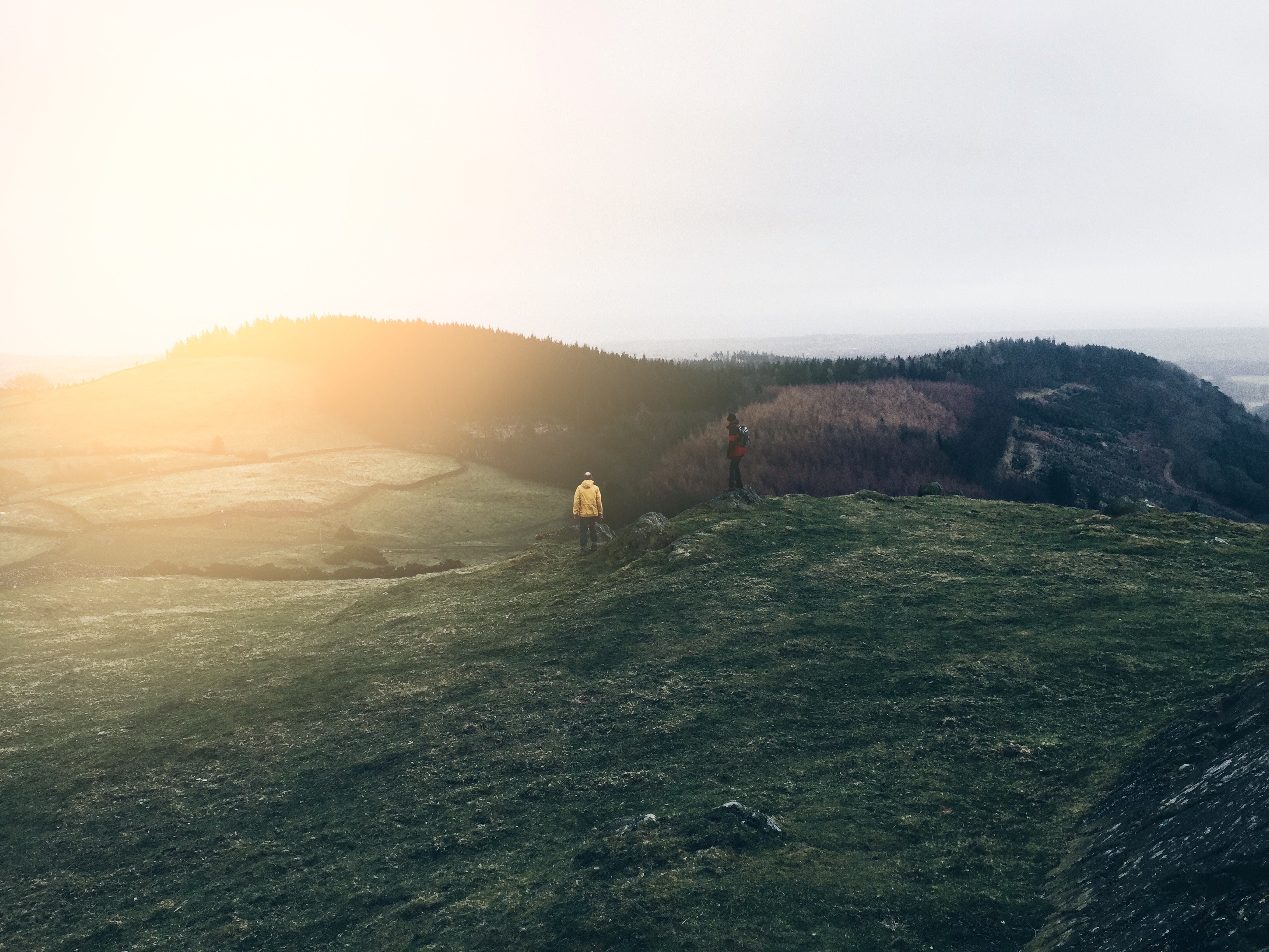 two hikers on a grassy slope in cark england on a bright autumn morning, hiking at sunrise 4k, HD Wallpaper