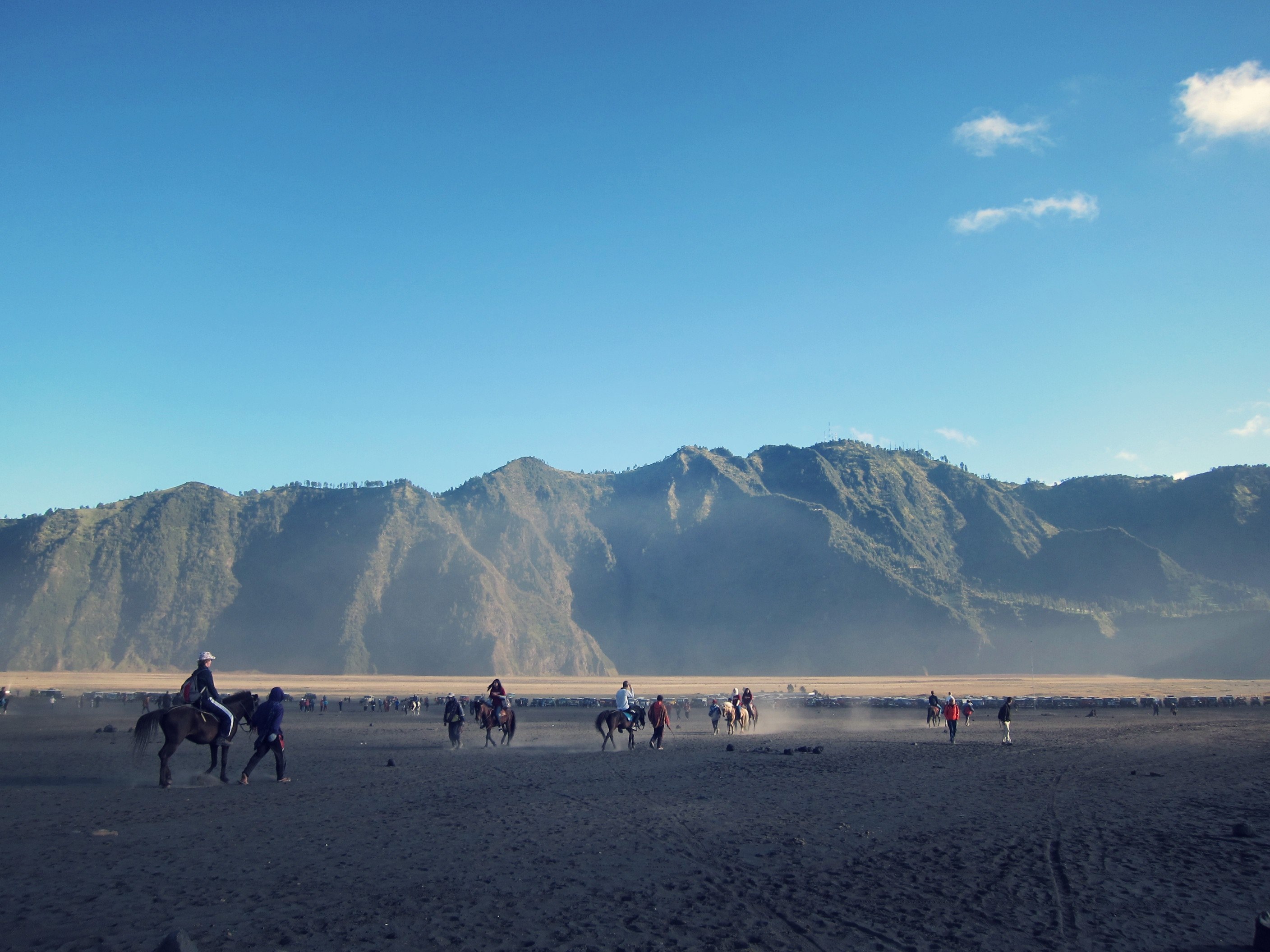 a plain at the foot of a mountain range with people on horseback and on foot, riding lessons in the mountains 4k, HD Wallpaper