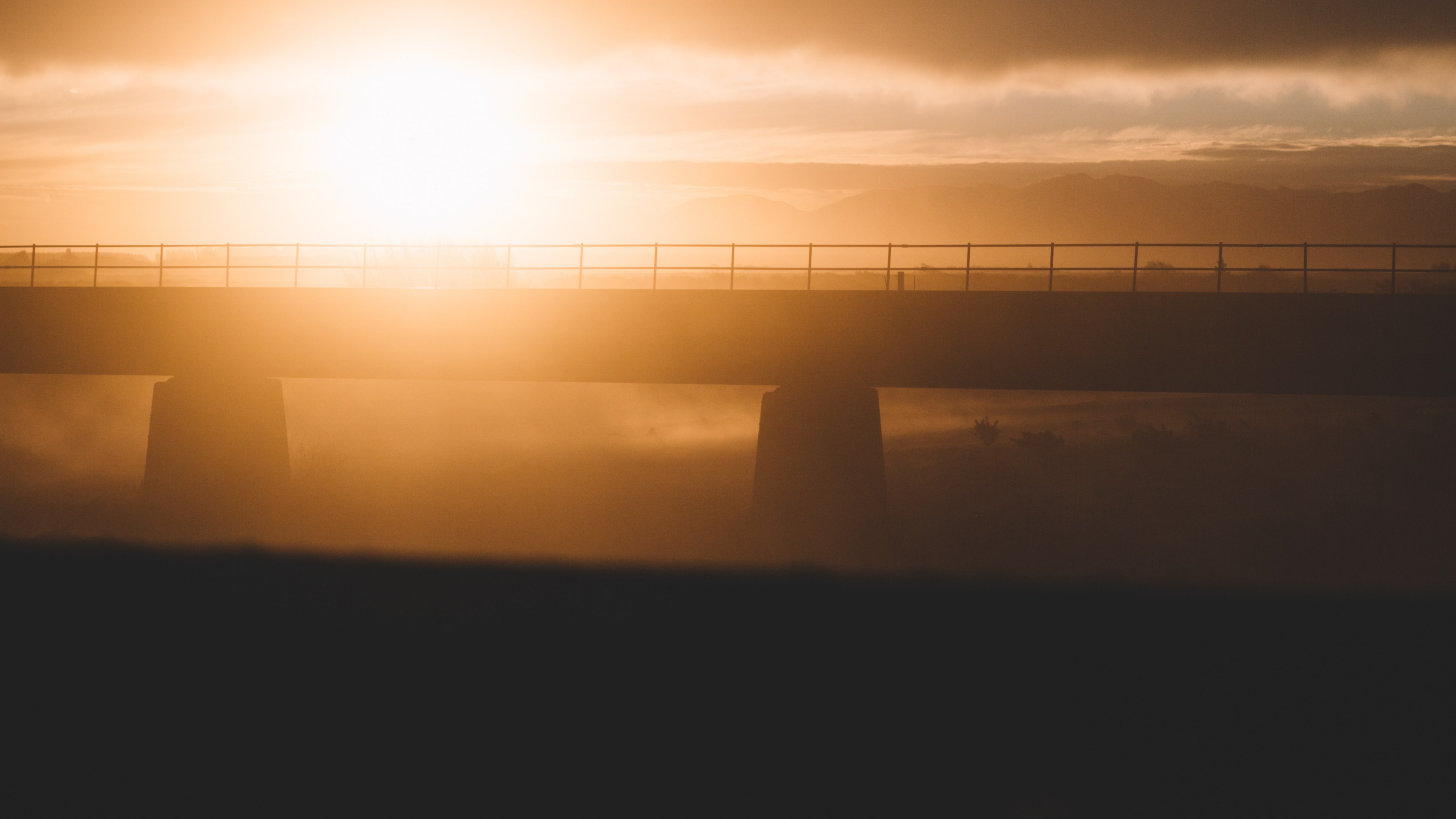 a hazy golden sunset puts a modern bridge into silhouette at rangitata river, rangitata river sunset_ 4k, HD Wallpaper