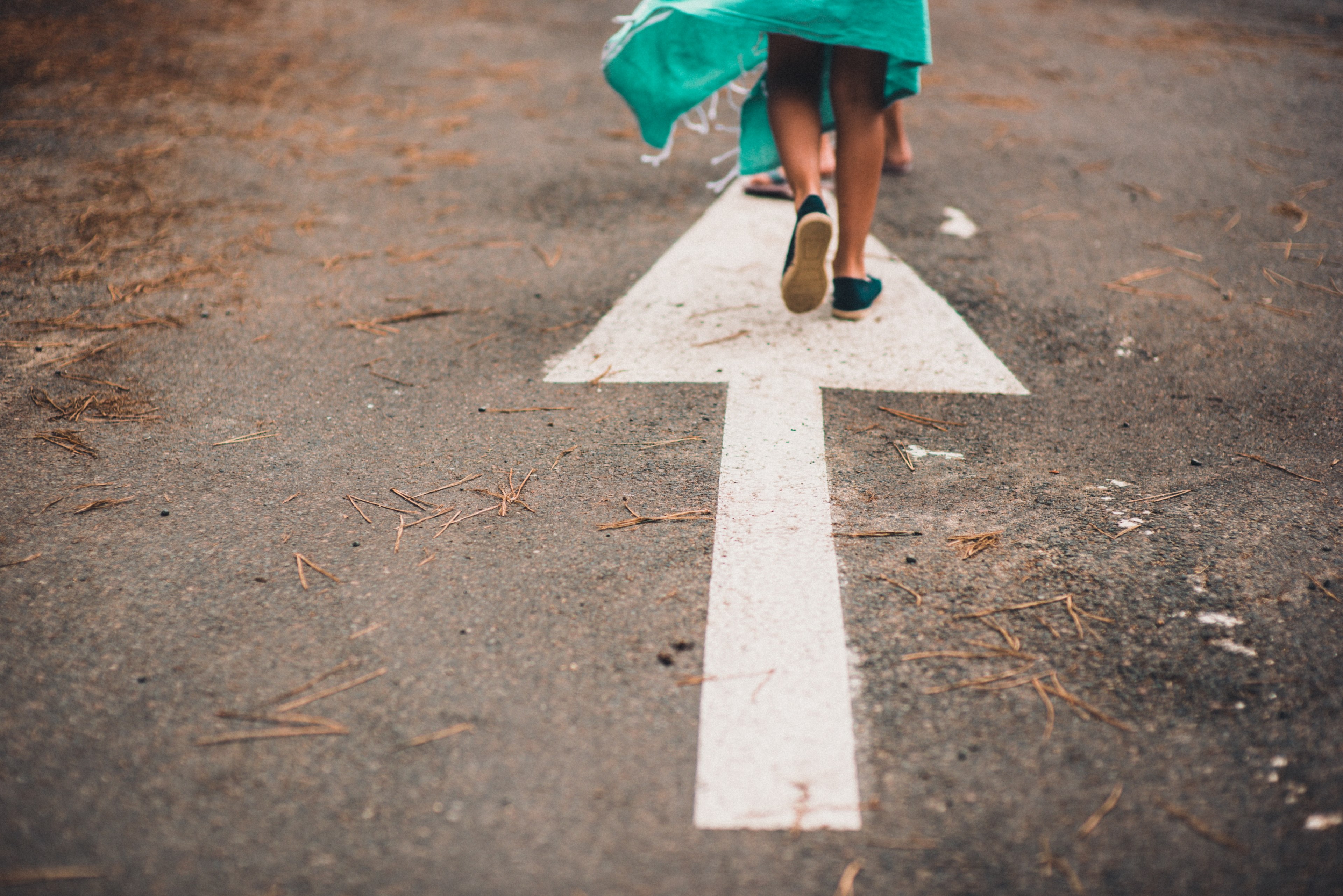 a low shot of a persons feet on a white arrow on a road, feet on a road arrow 4k, HD Wallpaper