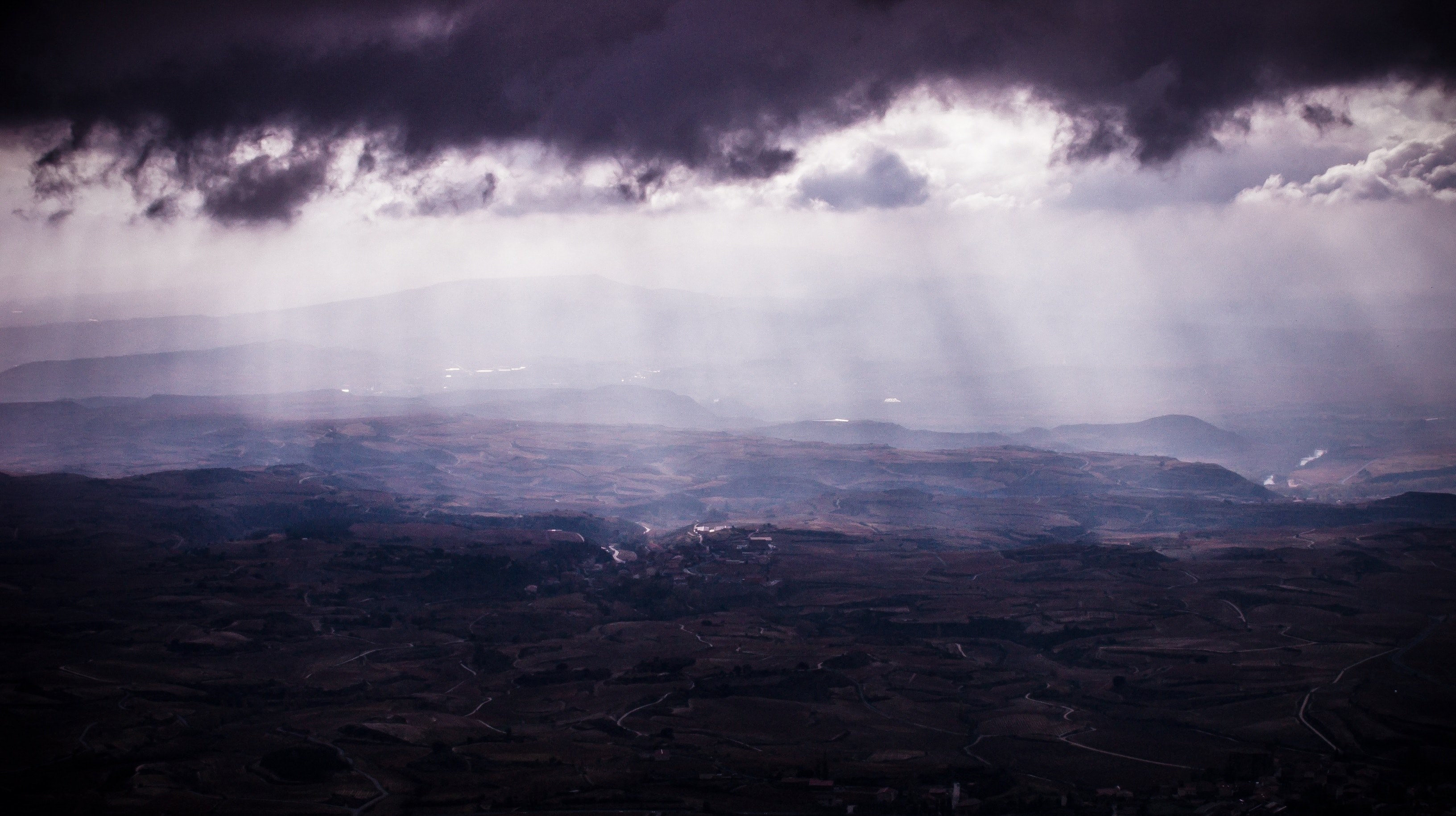 a vast rural landscape under faint light seeping in from the clouds, faint sunlight and countryside 4k, HD Wallpaper
