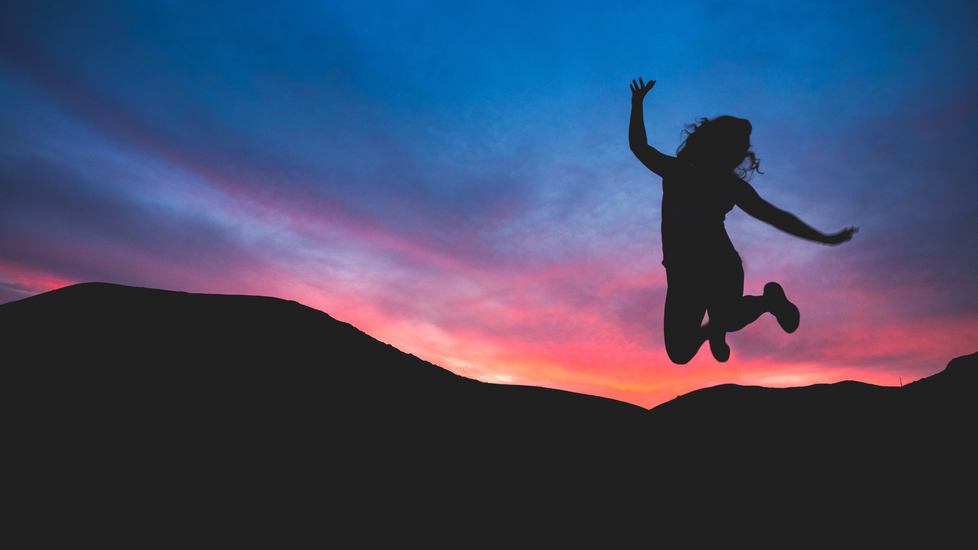 a woman in silhouette jumps for joy against dark mountains and a pink and purple sunset, joyful sunset_ 4k, HD Wallpaper
