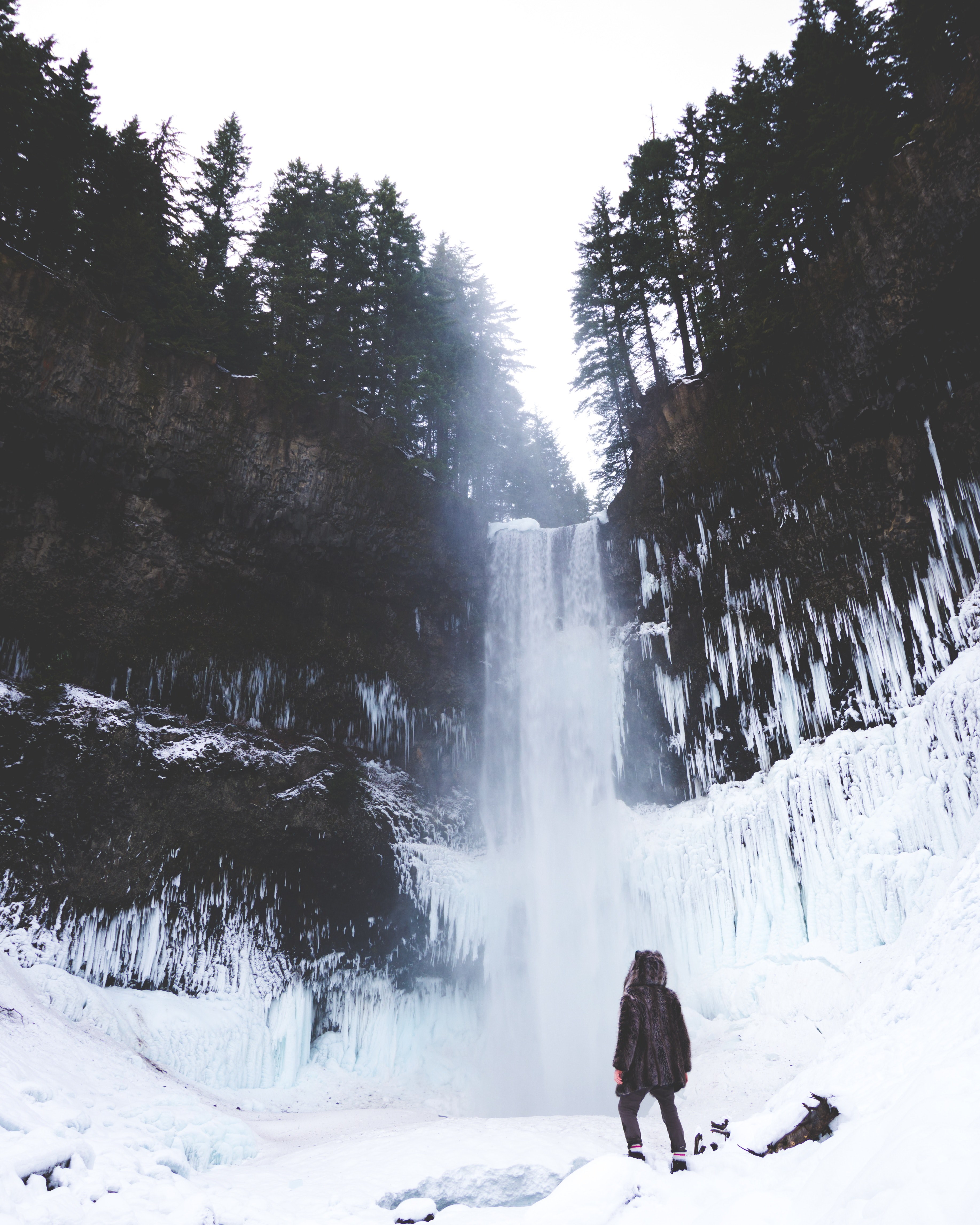 a person staring at the bottom of brandywine falls during a snowy winter season, watching a frozen waterfall in the forest 4k, Phone HD Wallpaper