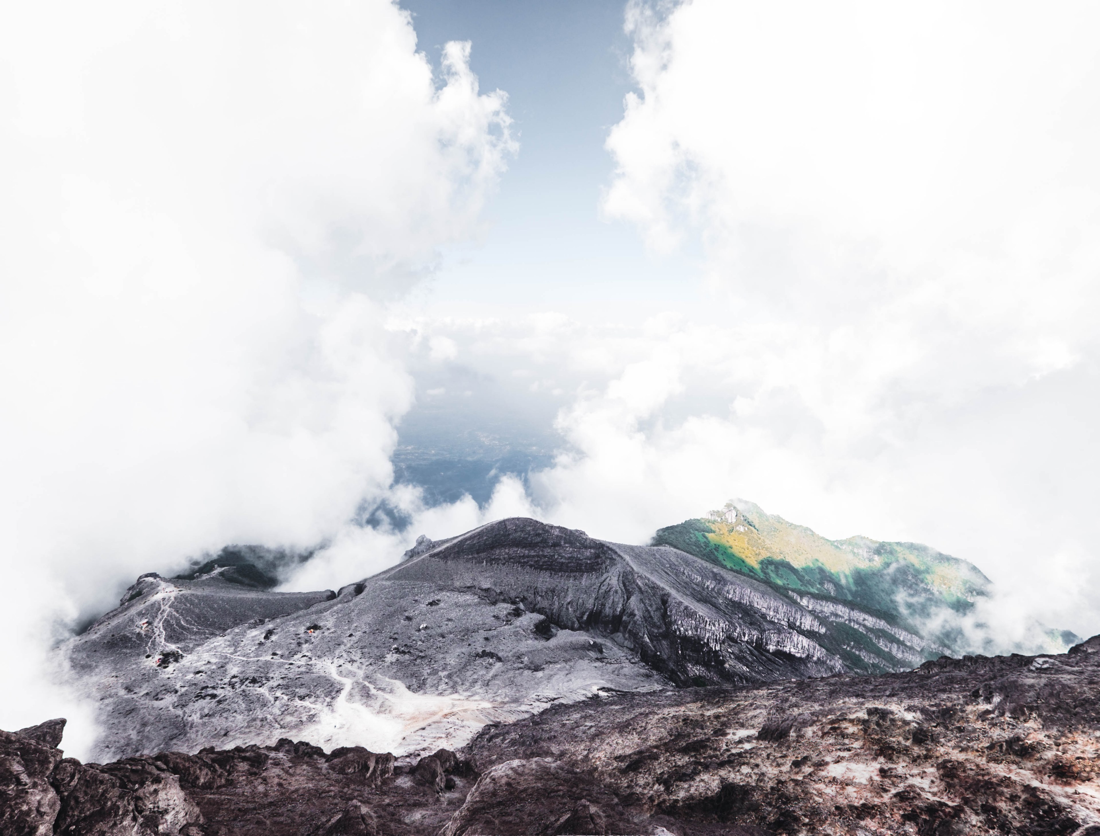 view down a rocky mountain slope with clouds framing the countryside below, view from mount merapi 4k, HD Wallpaper