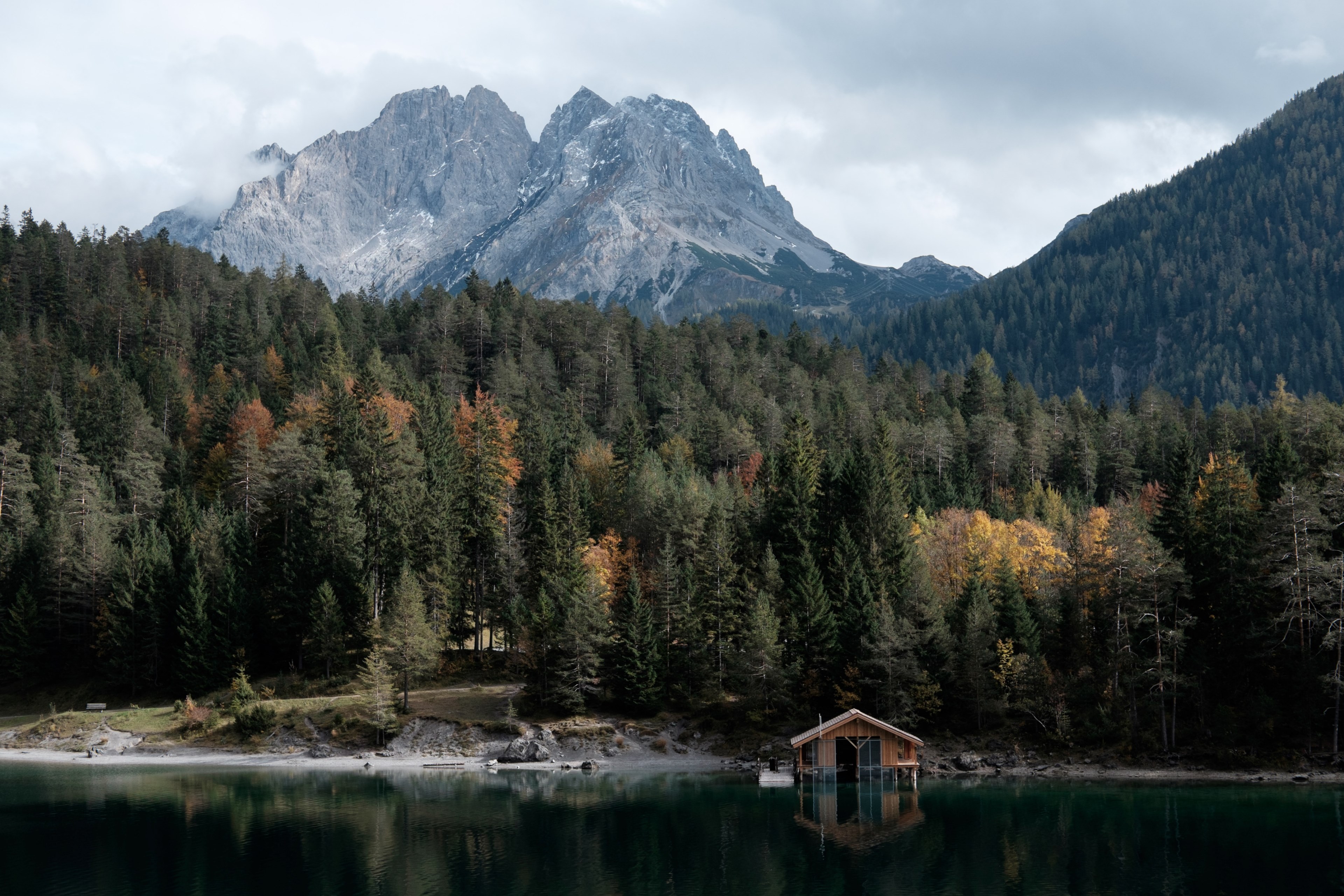 a boathouse on a quiet lake with imposing mountains on the horizon, boathouse near tall mountains 4k, HD Wallpaper