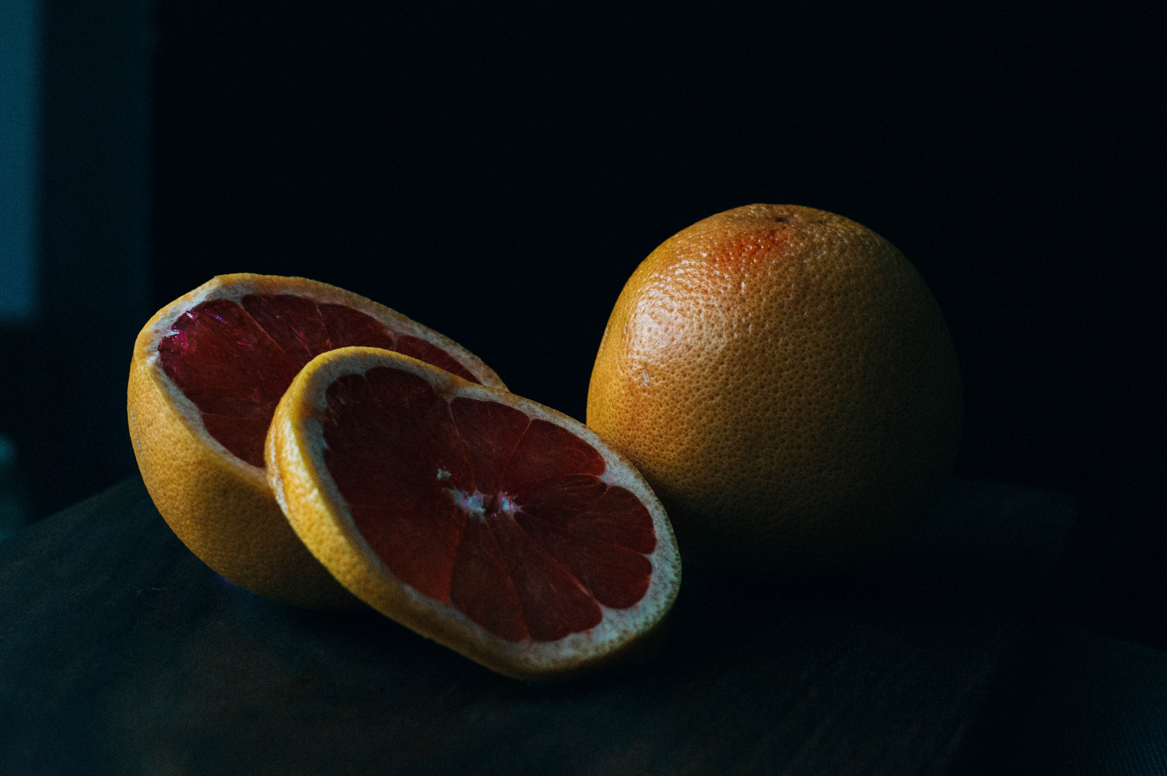 slices of fresh grapefruit on a black backdrop, shady grapefruit 4k, HD Wallpaper
