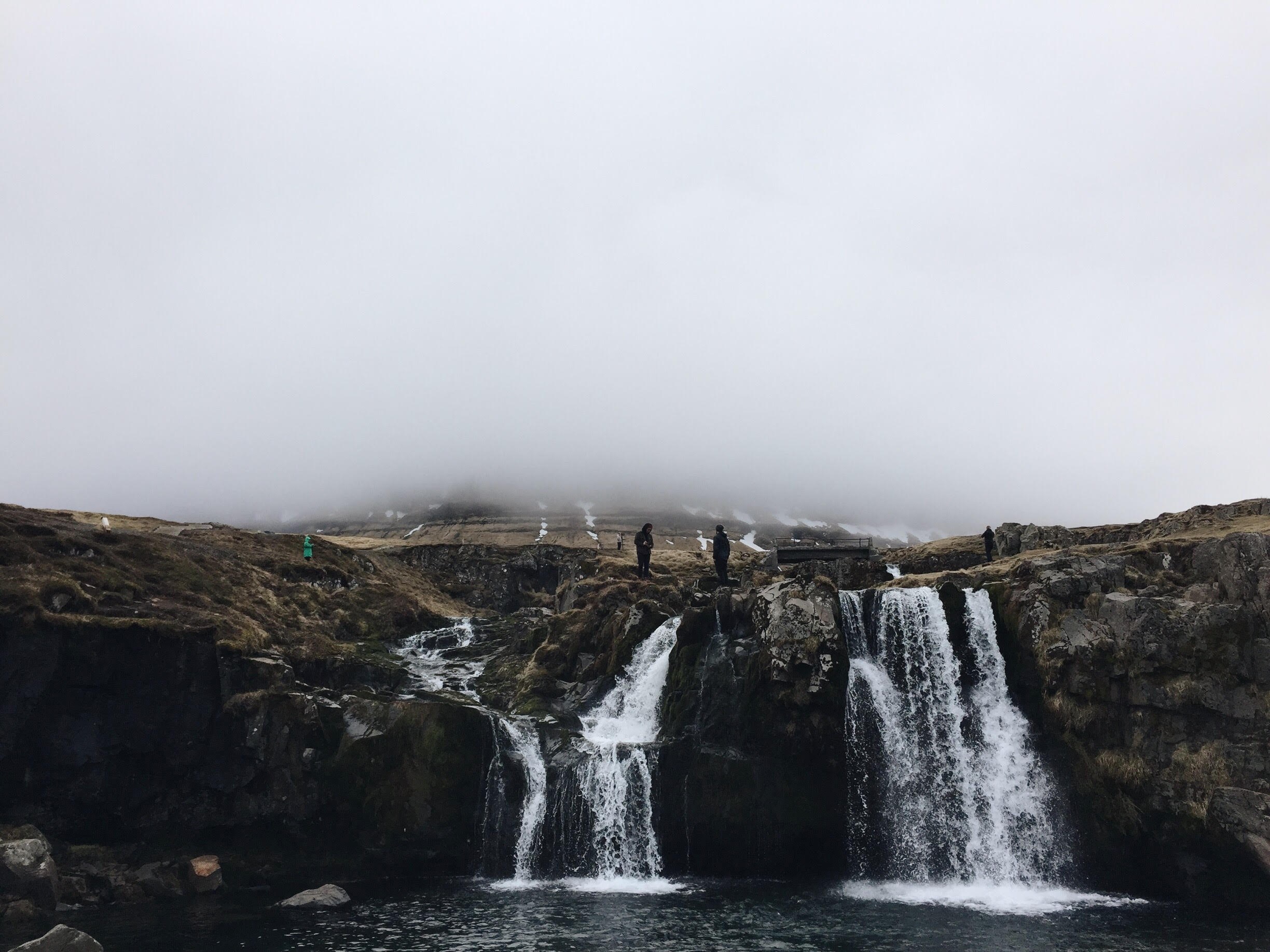 hikers stand atop waterfalls in kirkjufell on a misty day, waterfalls in kirkjufell 4k, HD Wallpaper