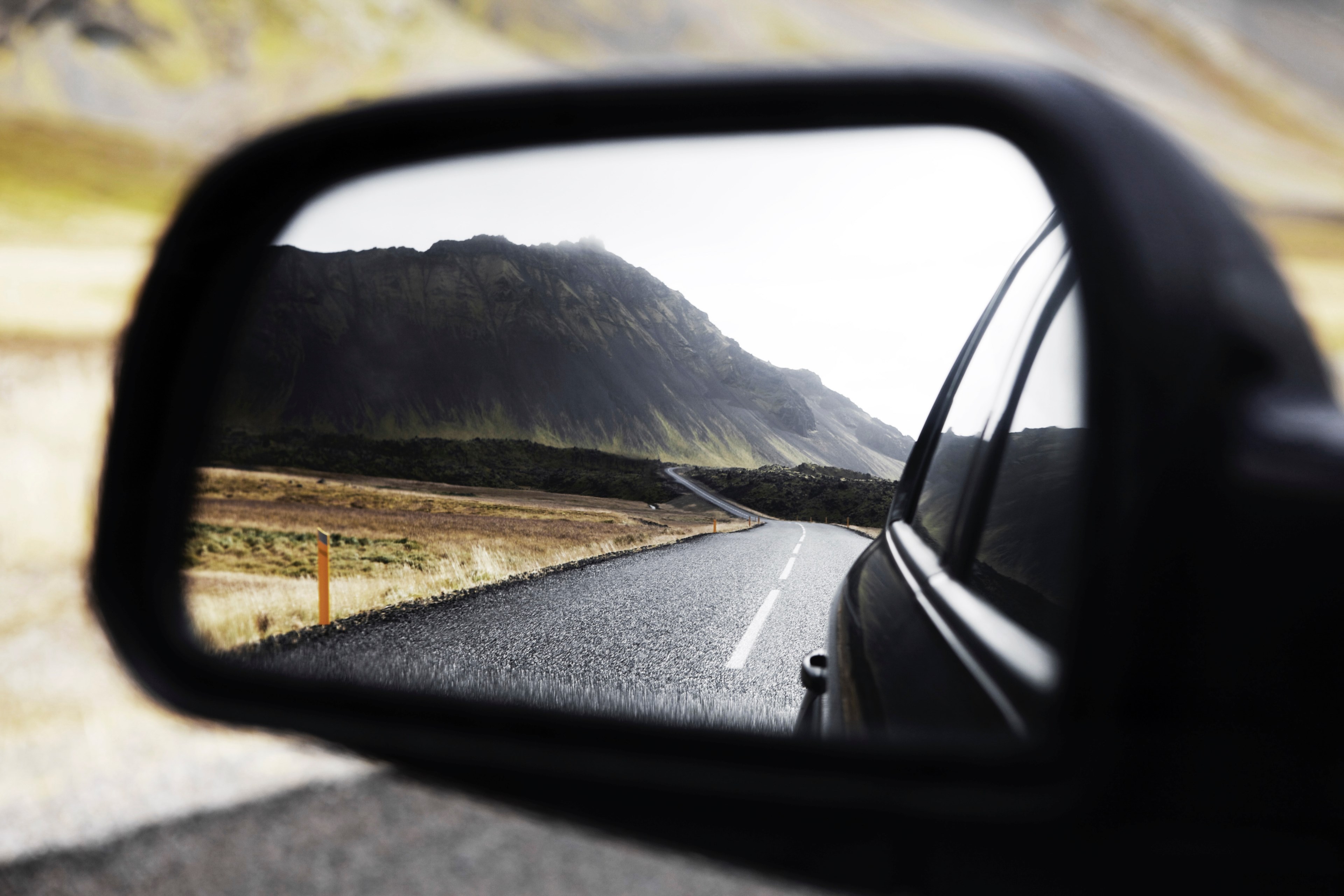 a winding highway cutting through a mountain a dark forest and a plain field reflected in a cars side view mirror, _rear view mirror snfellsjkull 4k, HD Wallpaper