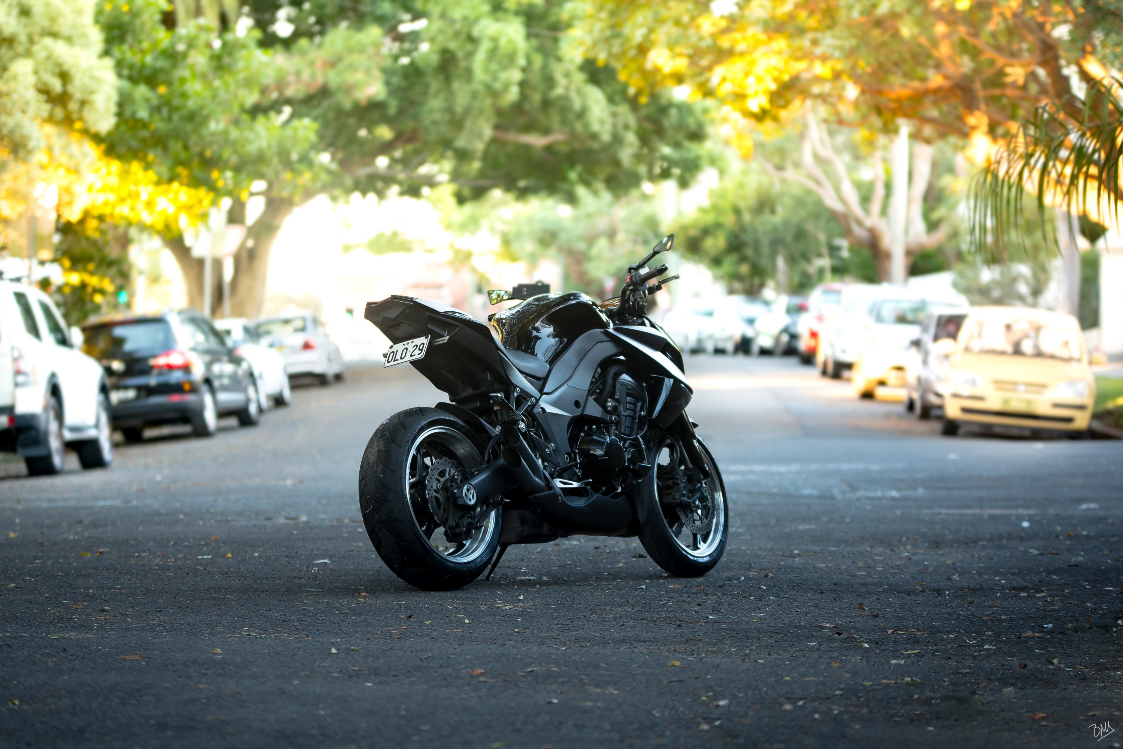 motorcycle in the middle of a road shaded by trees with cars parked on both sides, motorcycle parked in street 4k, HD Wallpaper