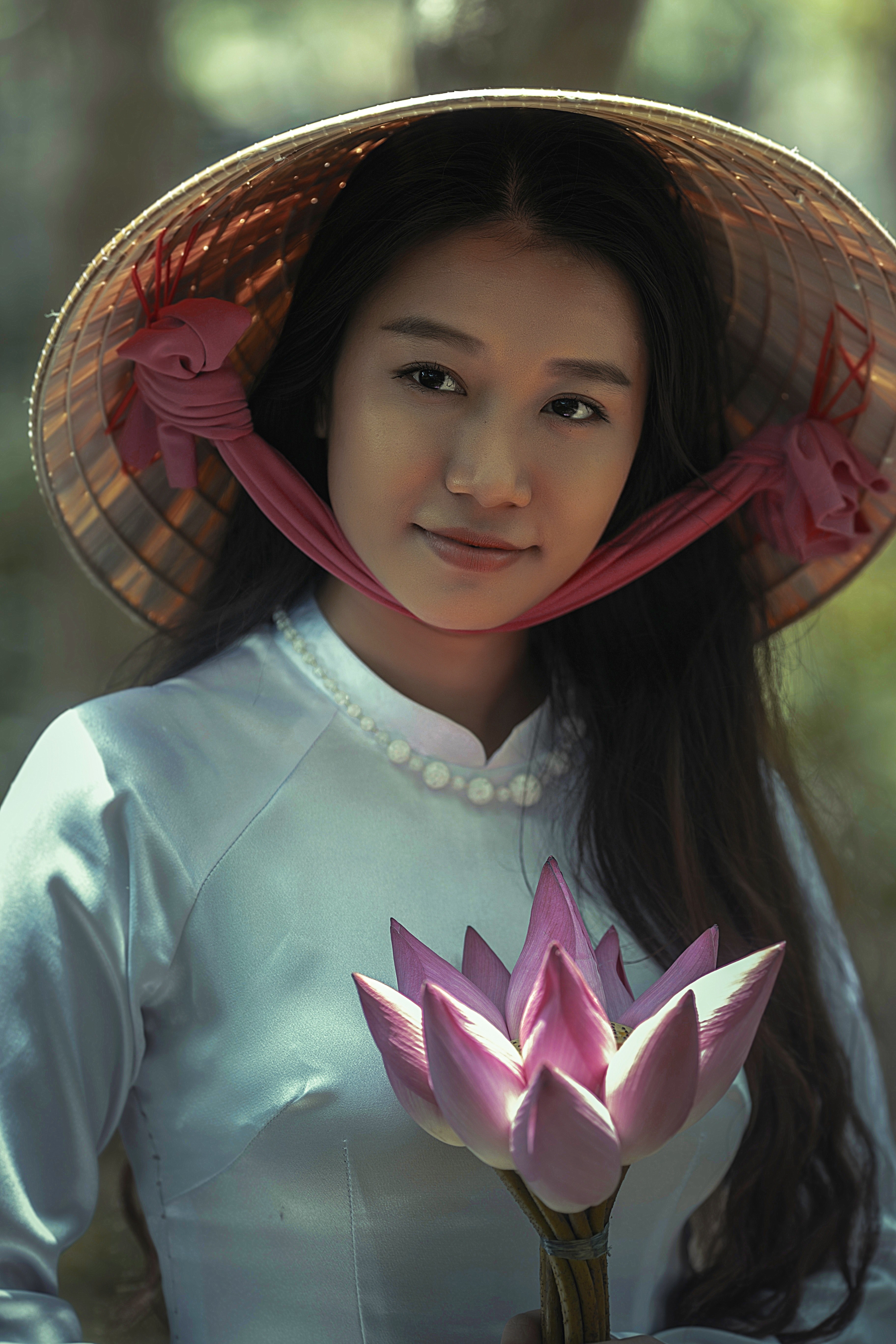a woman in a conical hat and silk clothing holds a flower in can tho, woman in hat in can tho 4k, Phone HD Wallpaper