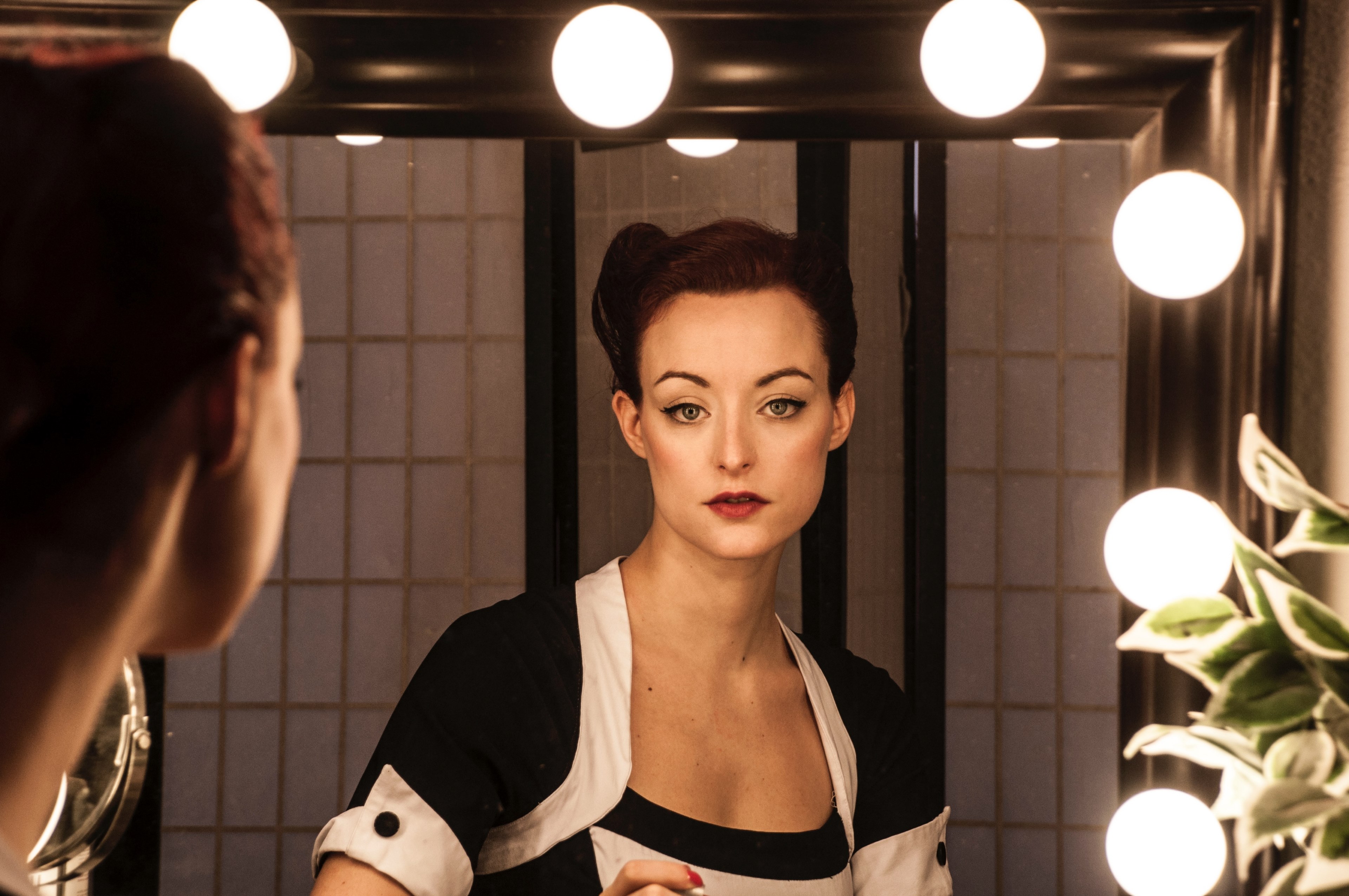 a woman in makeup and a black and white dress looks into a lighted mirror, mirror 4k, HD Wallpaper