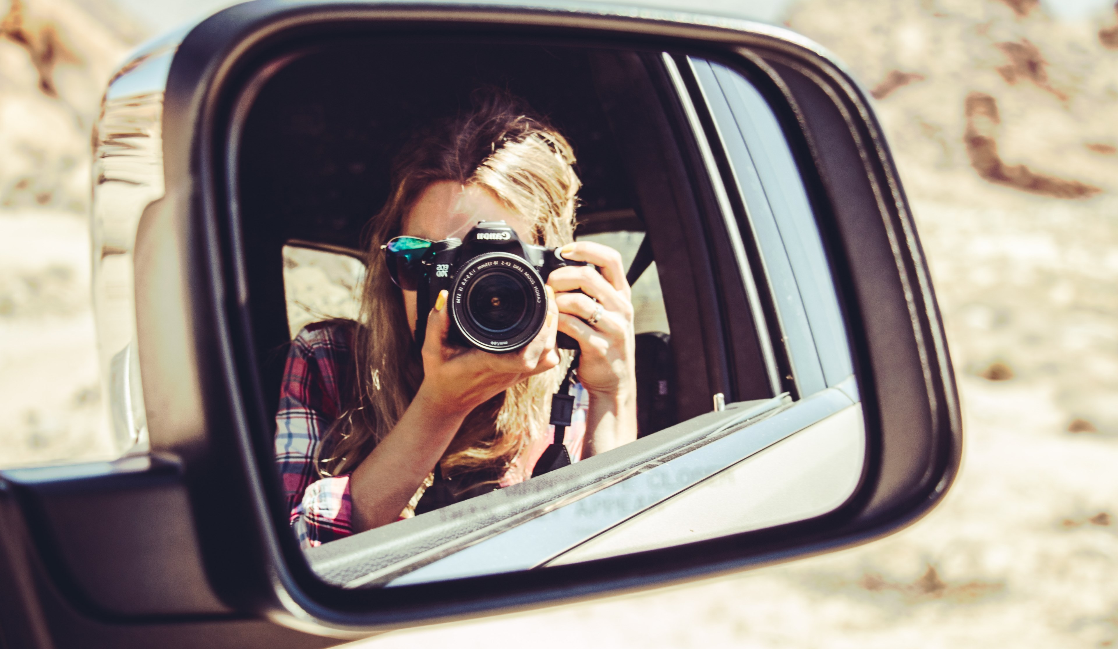 a blonde woman in pink plaid taking a photo of herself by pointing a canon camera at a sideview mirror, side view mirror selfie 4k, HD Wallpaper