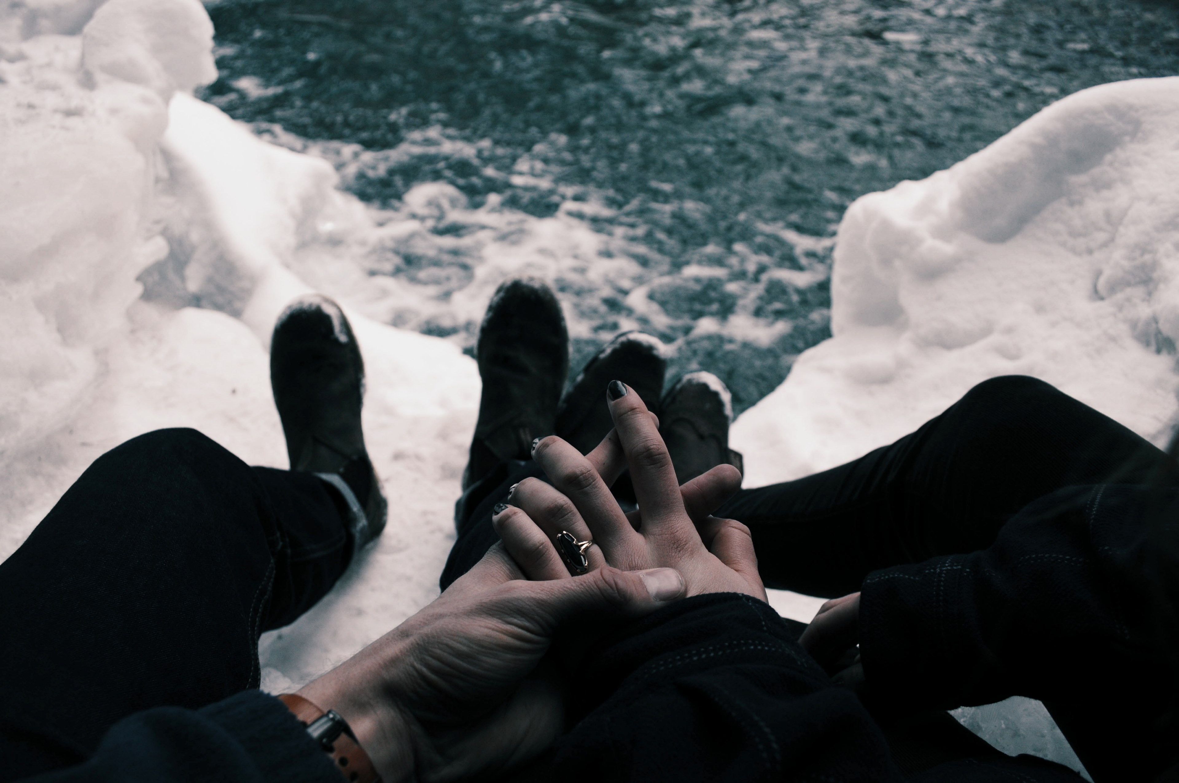 couple with hands clasped while sitting on icy mountaintop overlooking water, couple sitting on snow 4k, HD Wallpaper