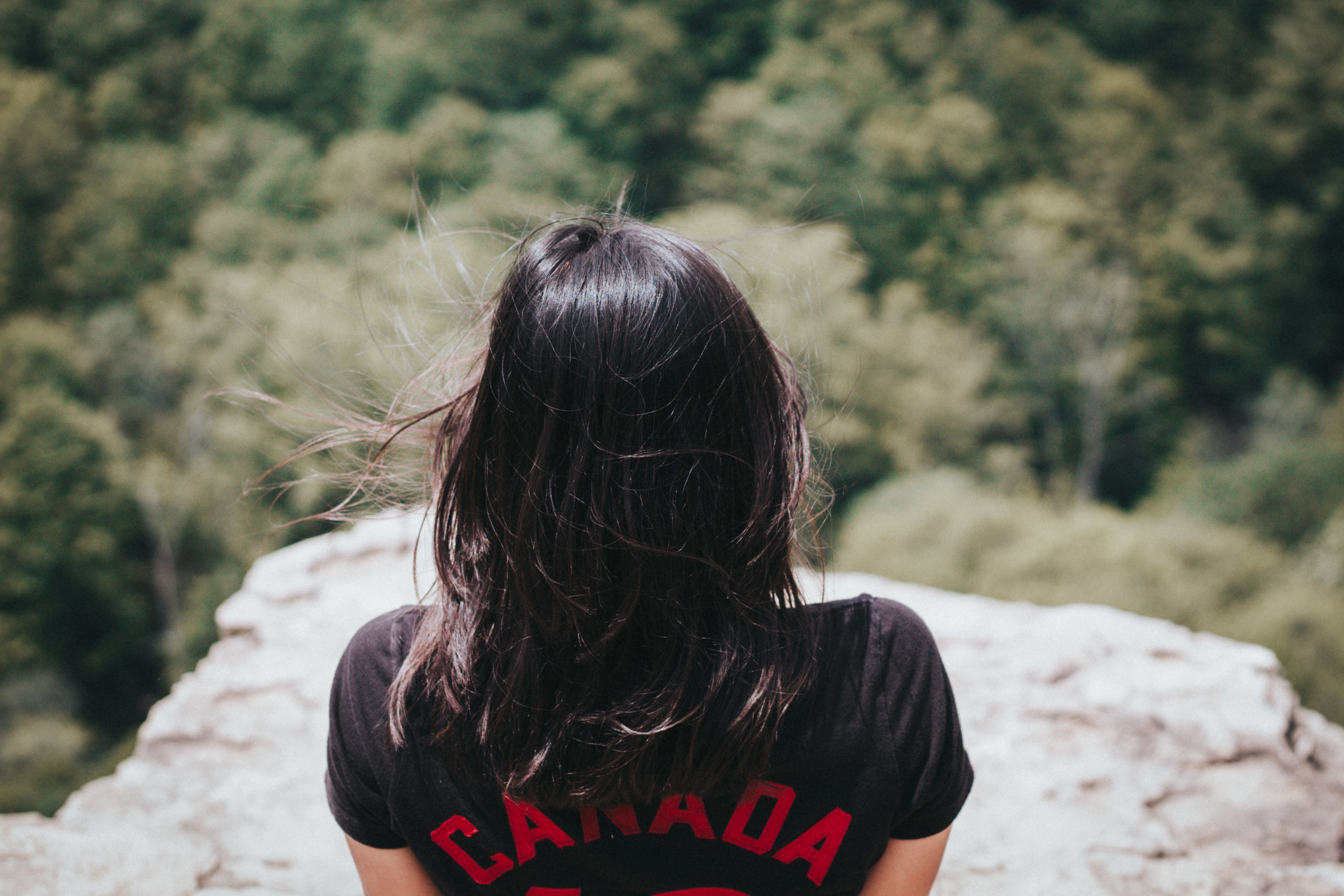 a brunette woman sitting on a rock with her back to camera, dark haired woman on a rock 4k, HD Wallpaper