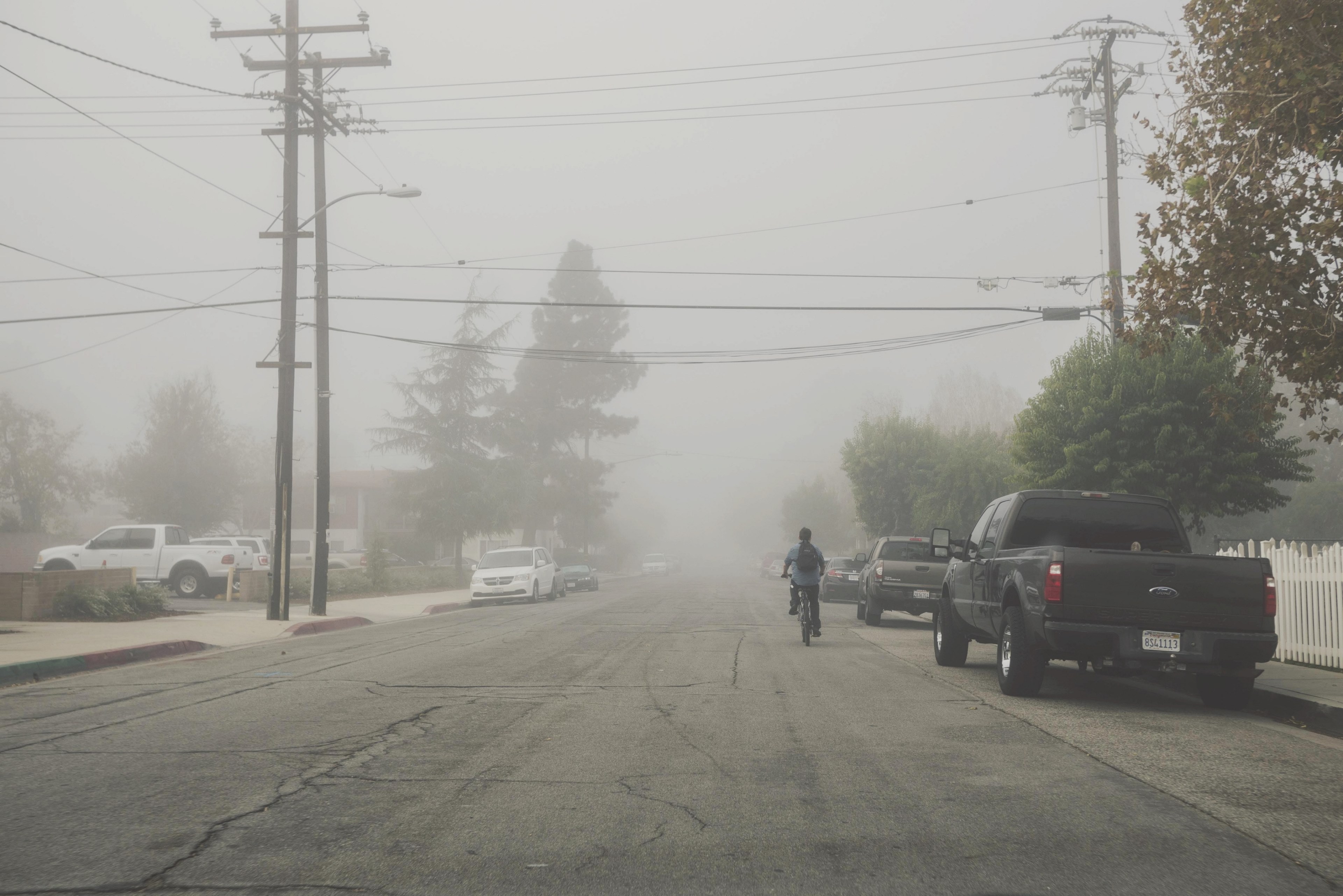 person bikes down a foggy suburban city street, biking on side streets 4k, HD Wallpaper