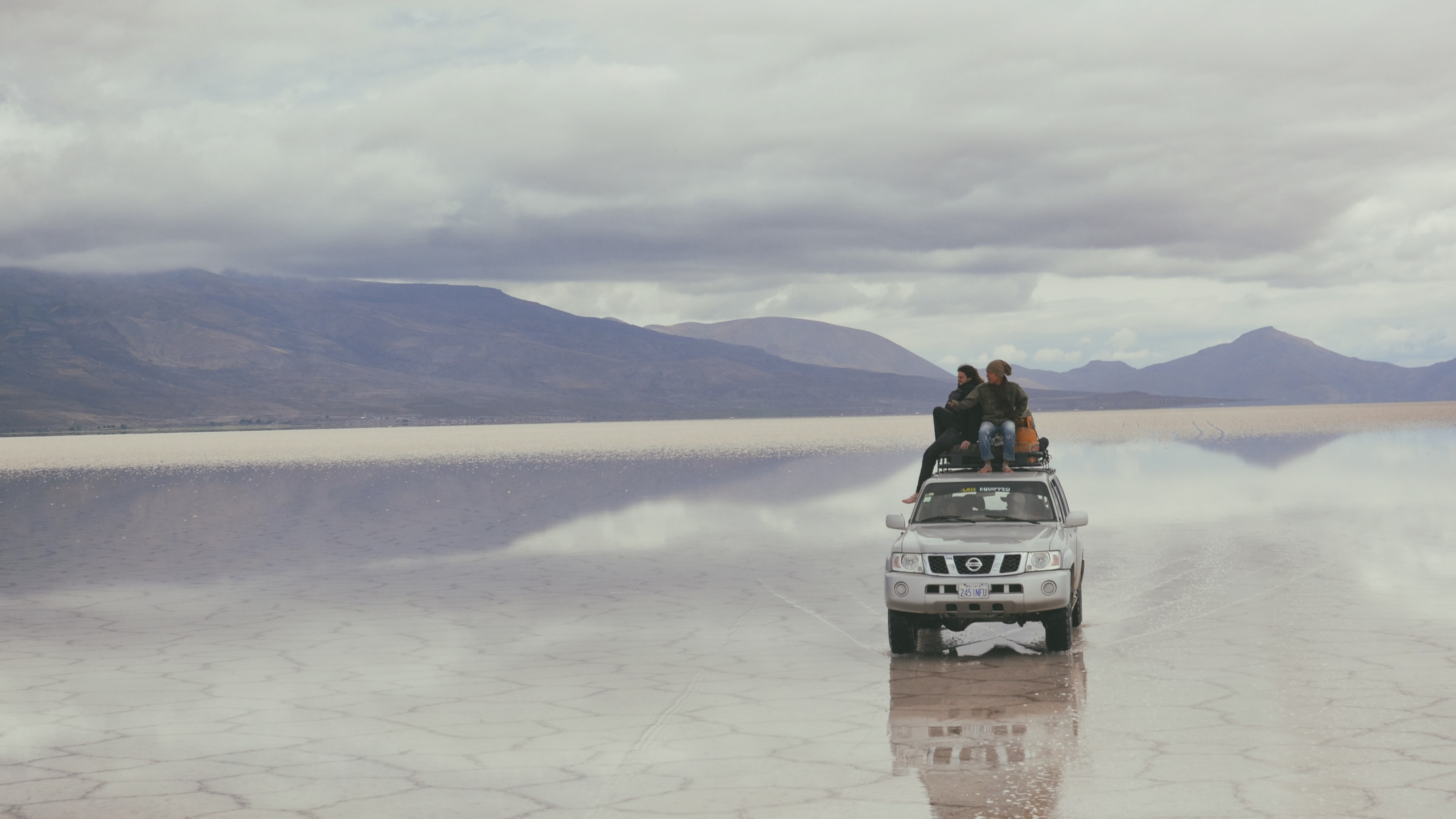 two people sat on the roof of a silver nissan jeep on a salt flat uyuni, nissan jeep uyuni salt flat 4k, HD Wallpaper