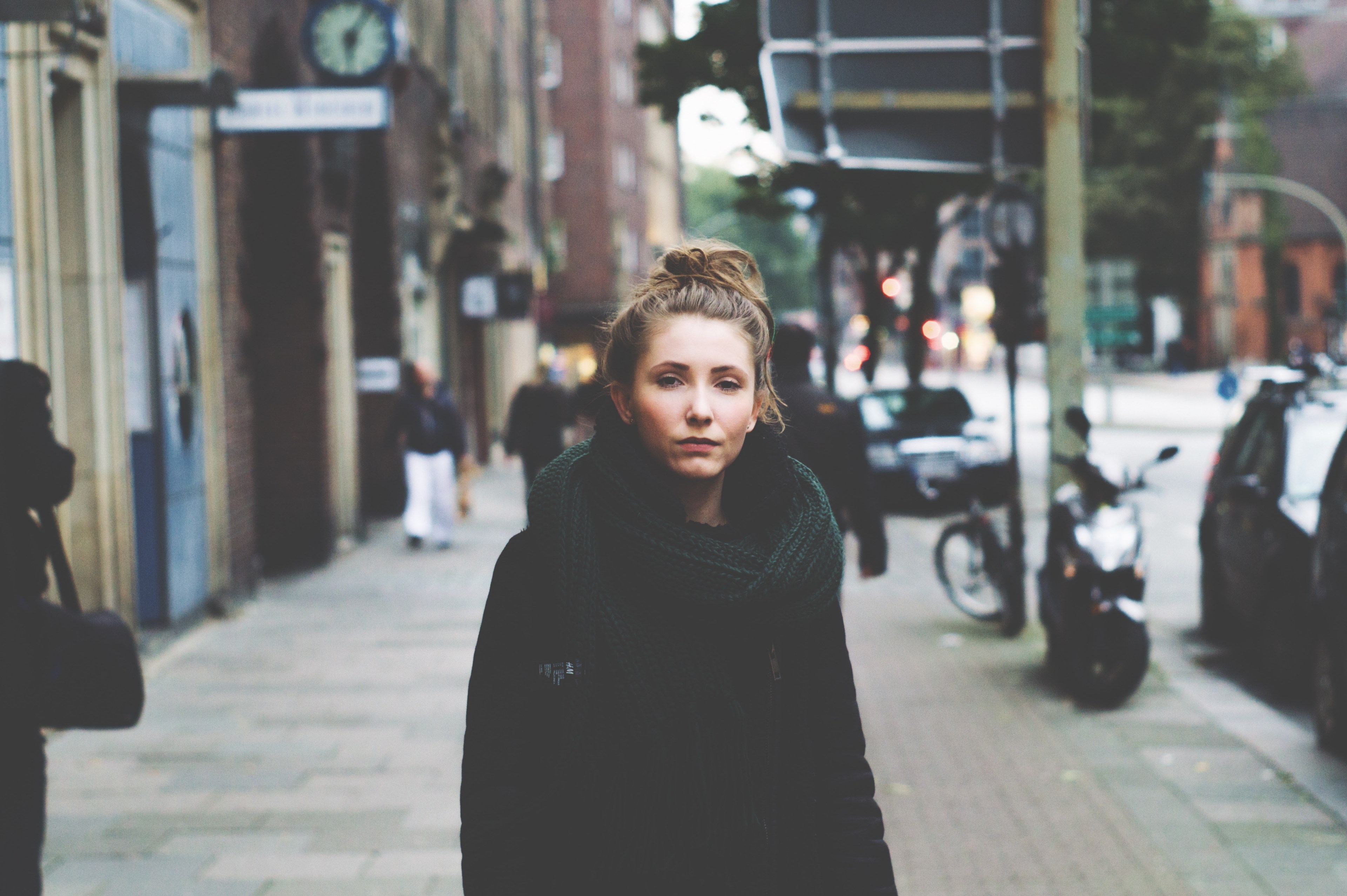 woman with a messy bun wearing a scarf and winter coat on a city street, lost in the city 4k, HD Wallpaper
