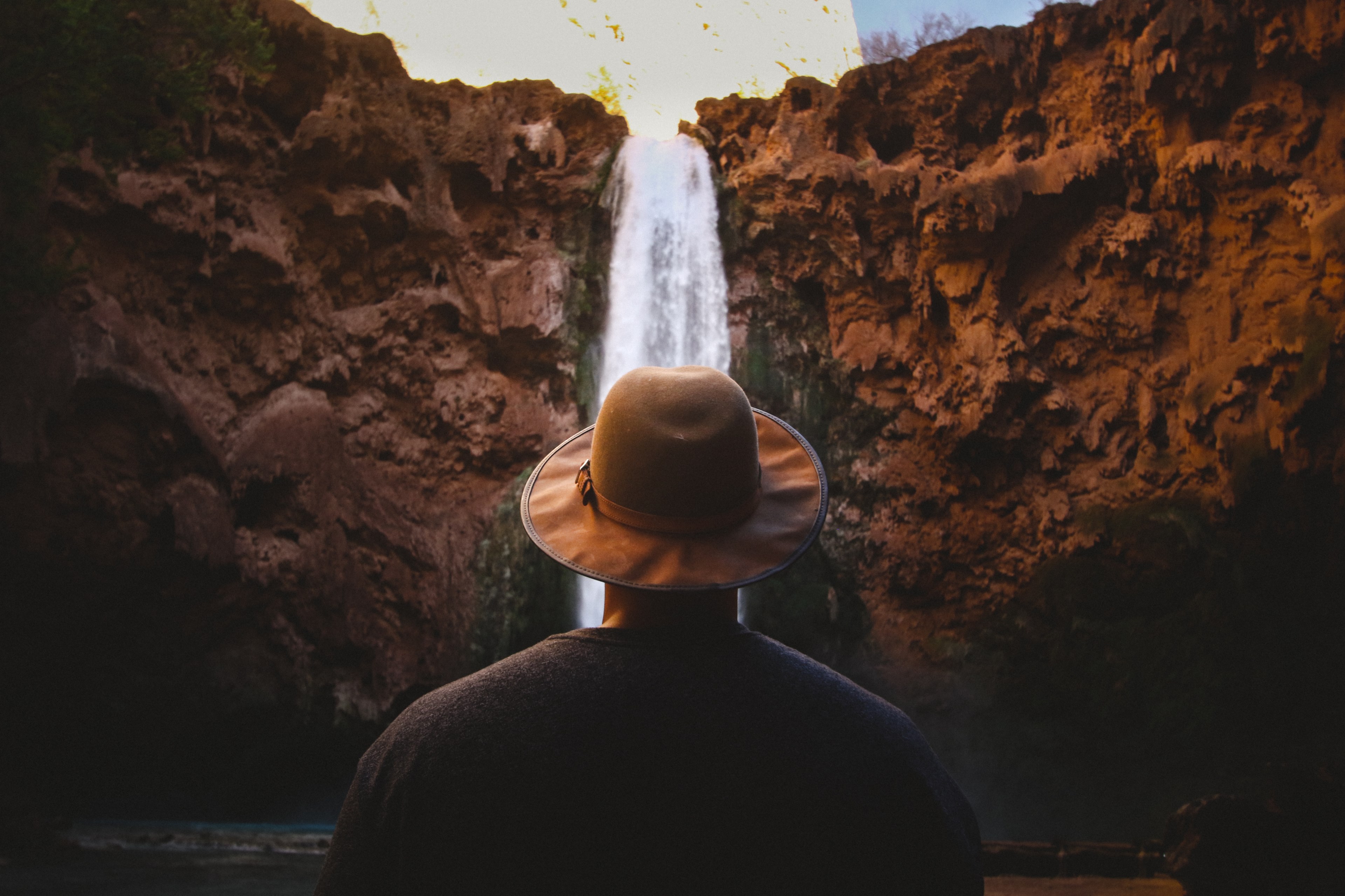a man wearing a hat stares at waterfalls falling from a cliff in supai arizona, left in awe of havasupi falls 4k, HD Wallpaper