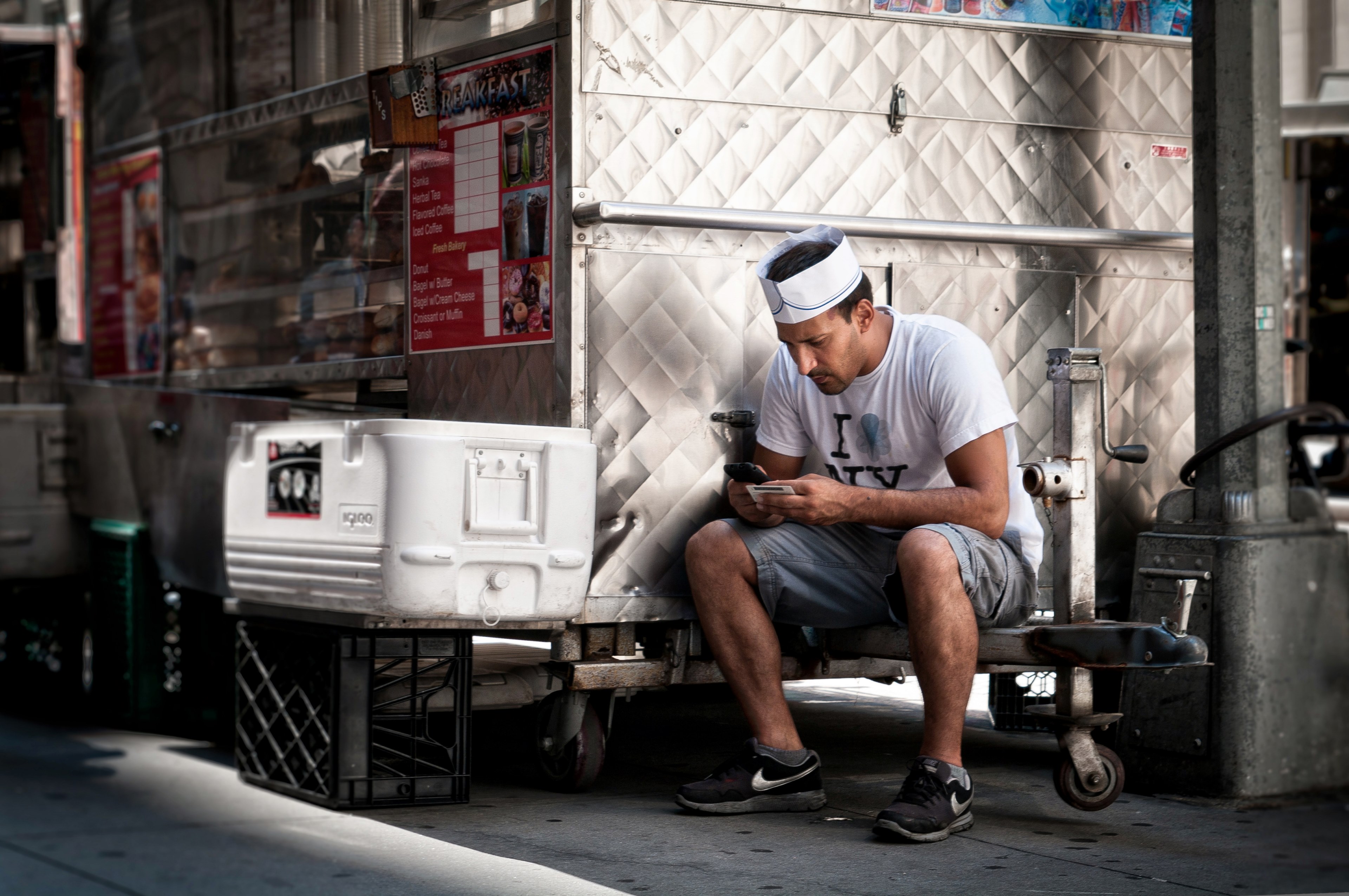 a man sits on the side of a food truck using his cell phone, man sitting on food truck 4k, HD Wallpaper