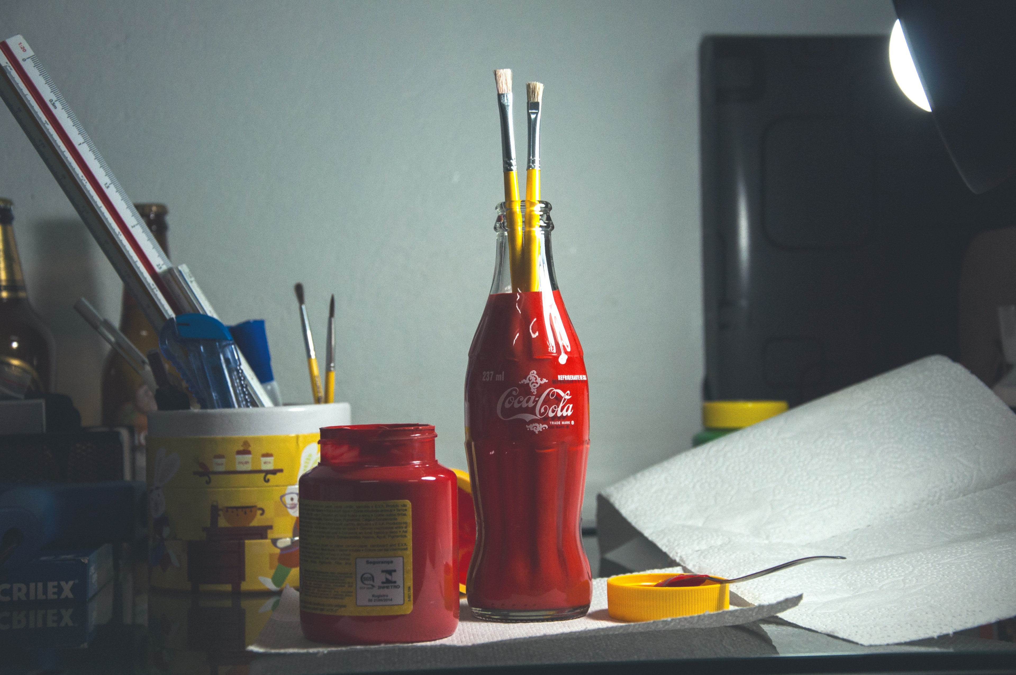 a coca cola bottle used as a beaker to hold paint brushes with other beakers, beakers of paint brushes 4k, HD Wallpaper