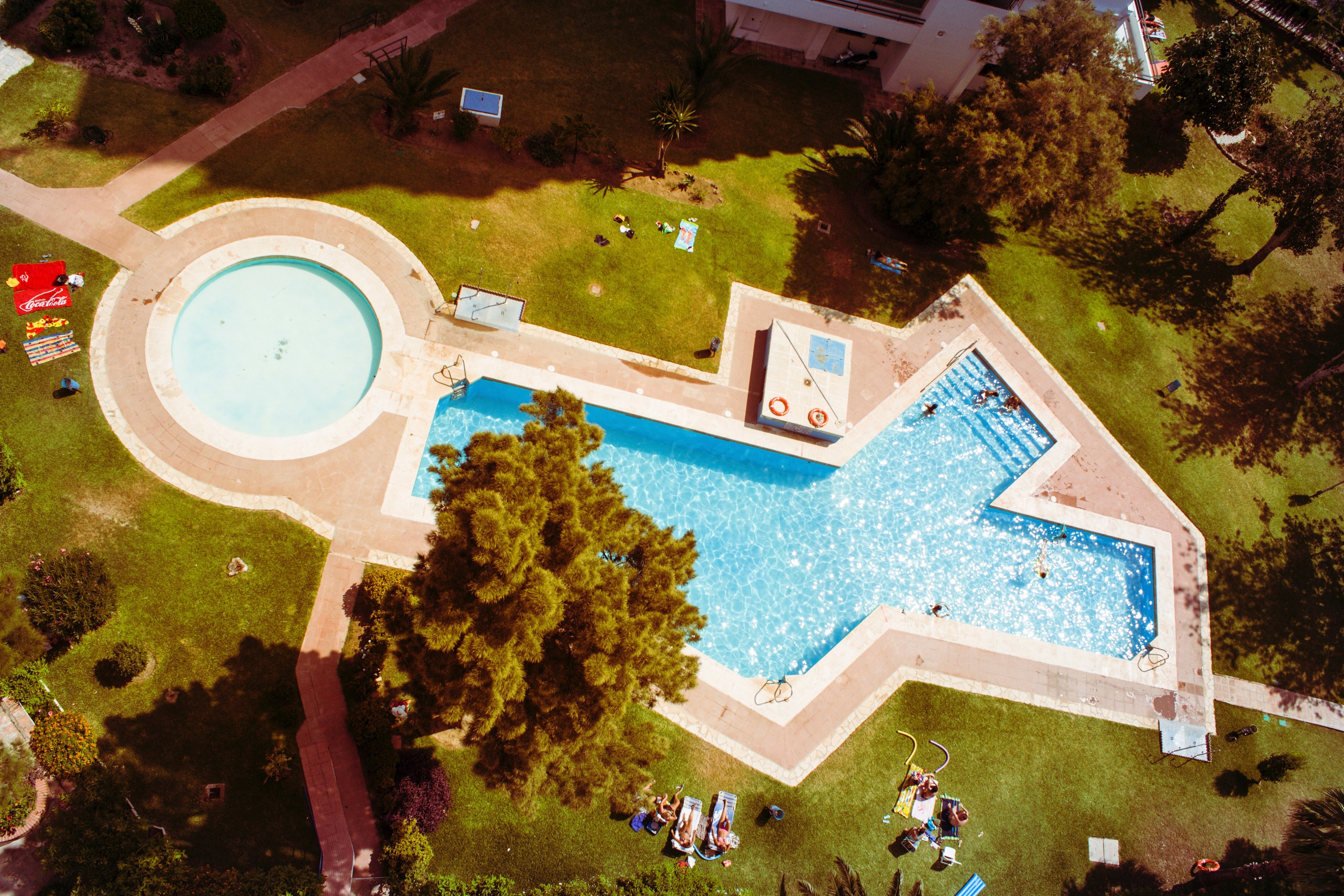 drone view of pool in shape of x and o with swimming and sunbathing people, drone pool x and o shape 4k, HD Wallpaper