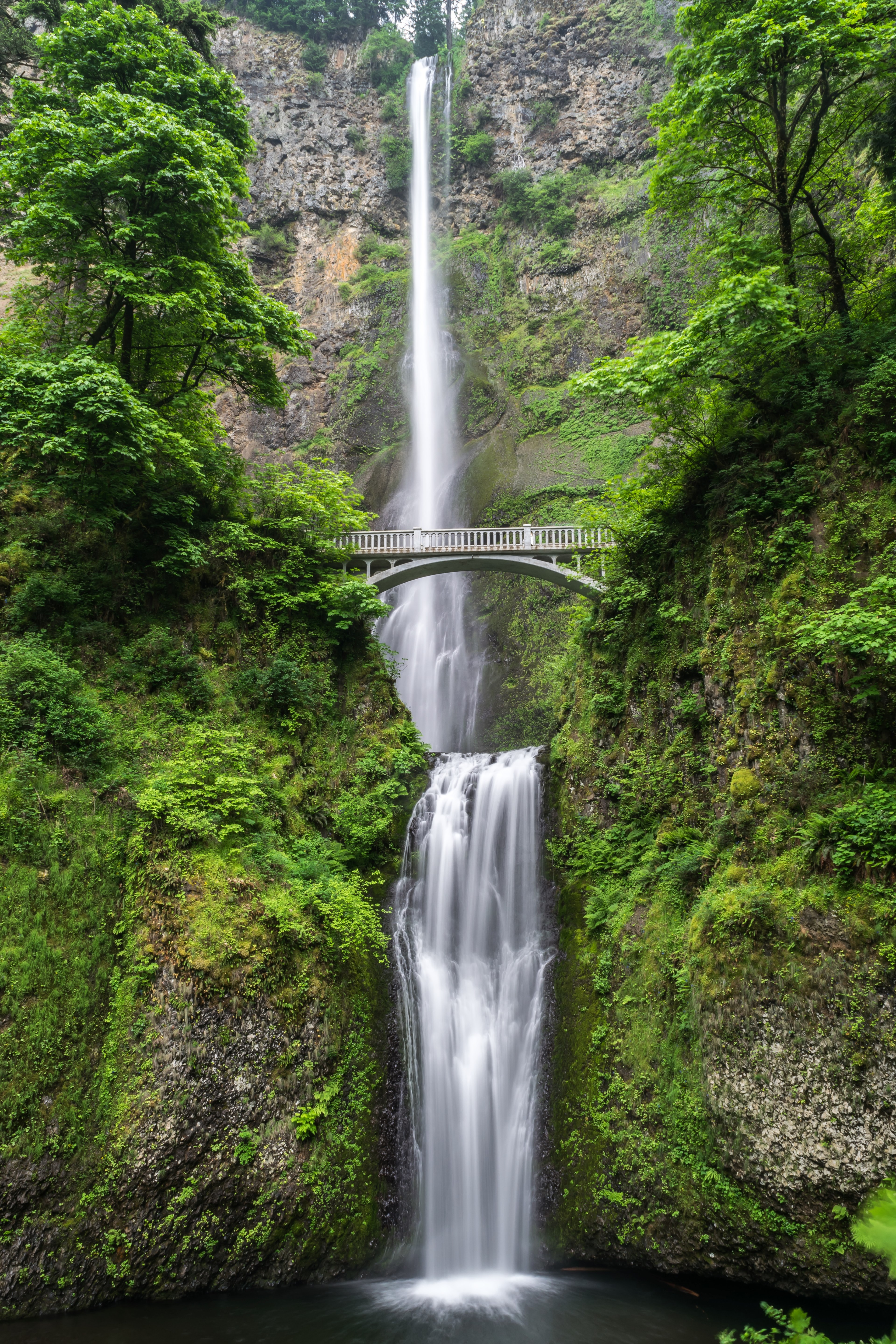 an empty white bridge over a waterfall tumbling down from a rocky face, bridge over a green waterfall 4k, Phone HD Wallpaper