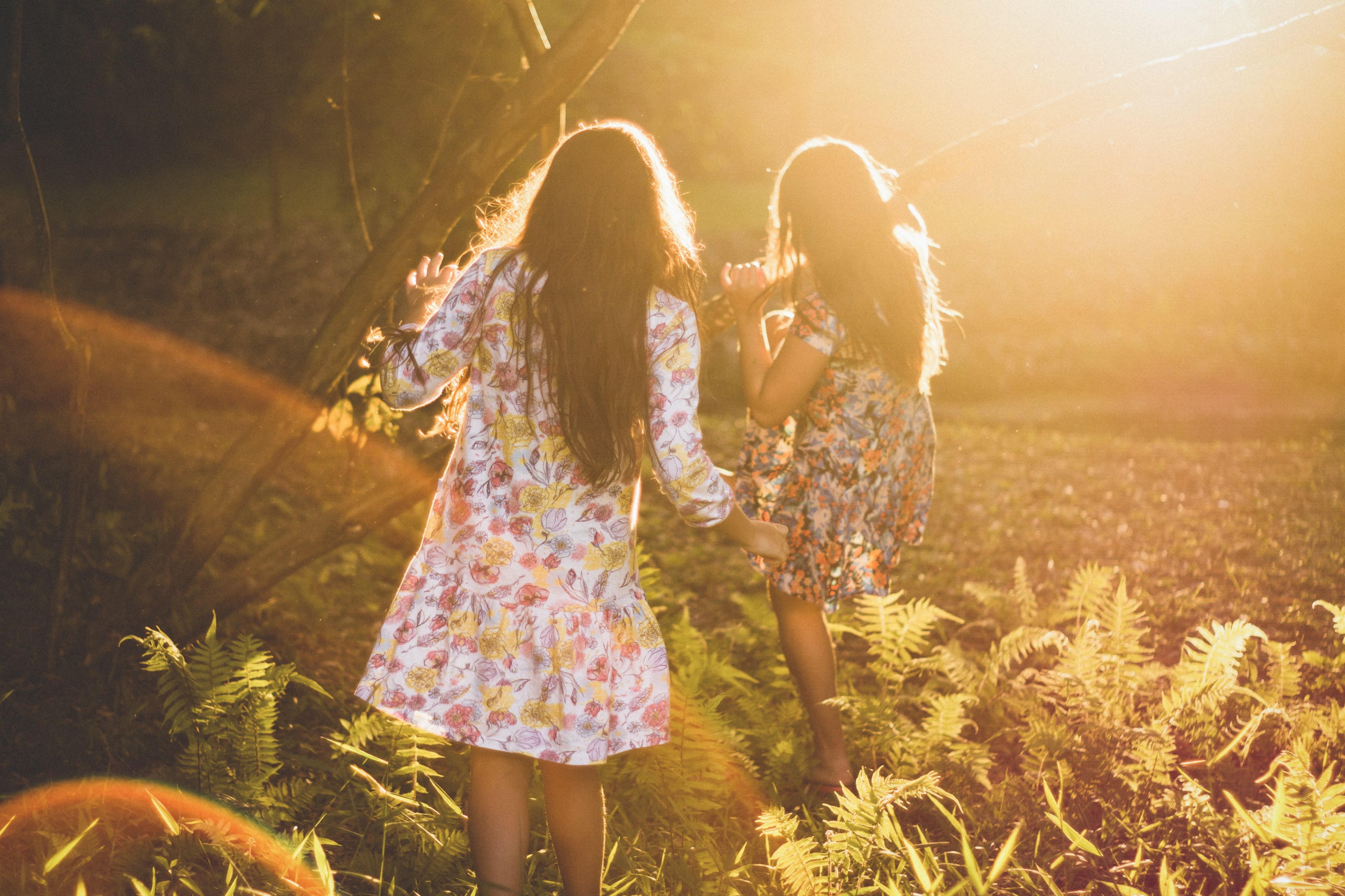 two girls wearing floral dresses play in a sunny field in juiz de fora, girls playing in field 4k, HD Wallpaper