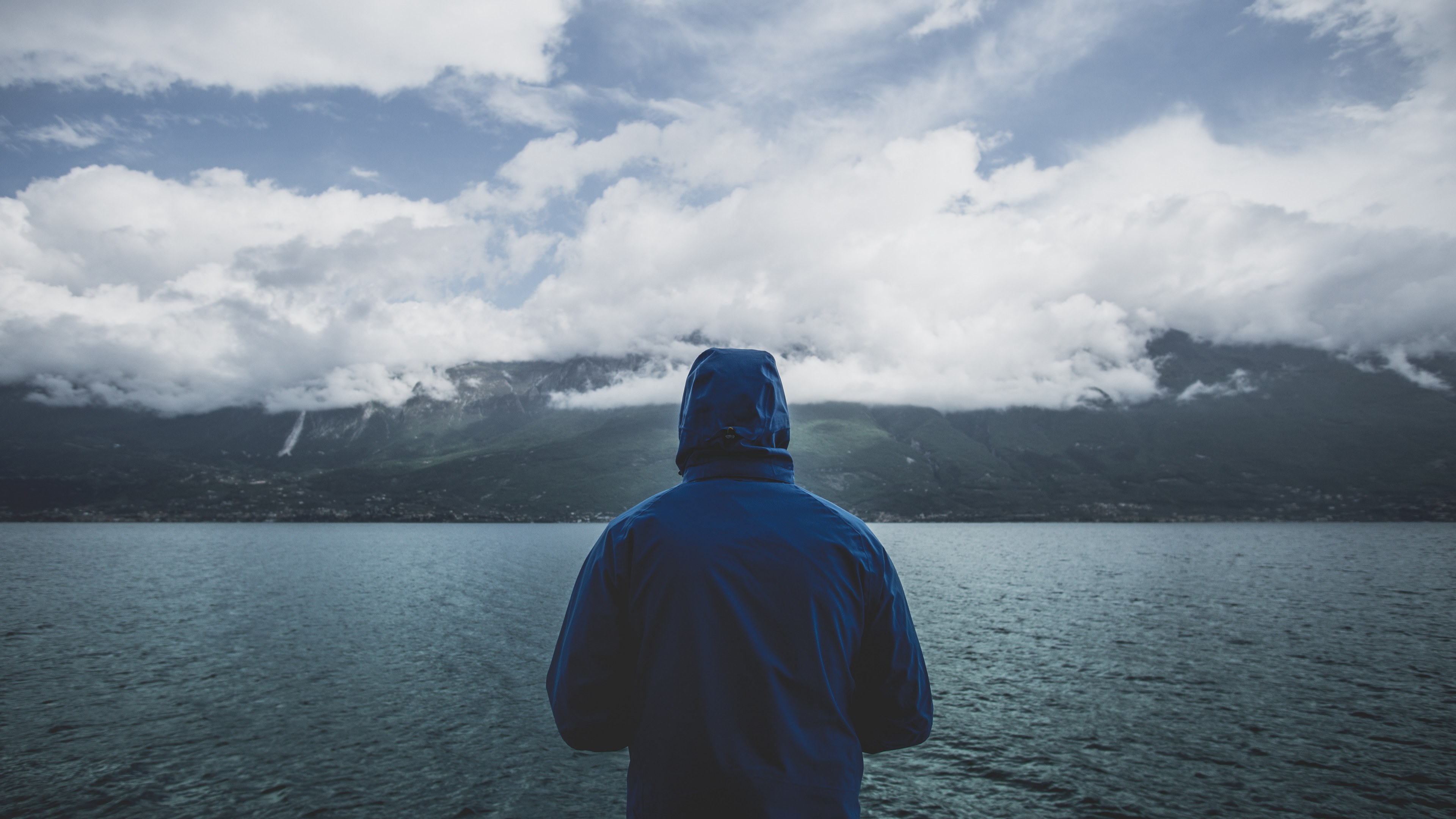 a man in a blue jacket staring out into a lake on a cloudy day, gazing at the lake 4k, HD Wallpaper