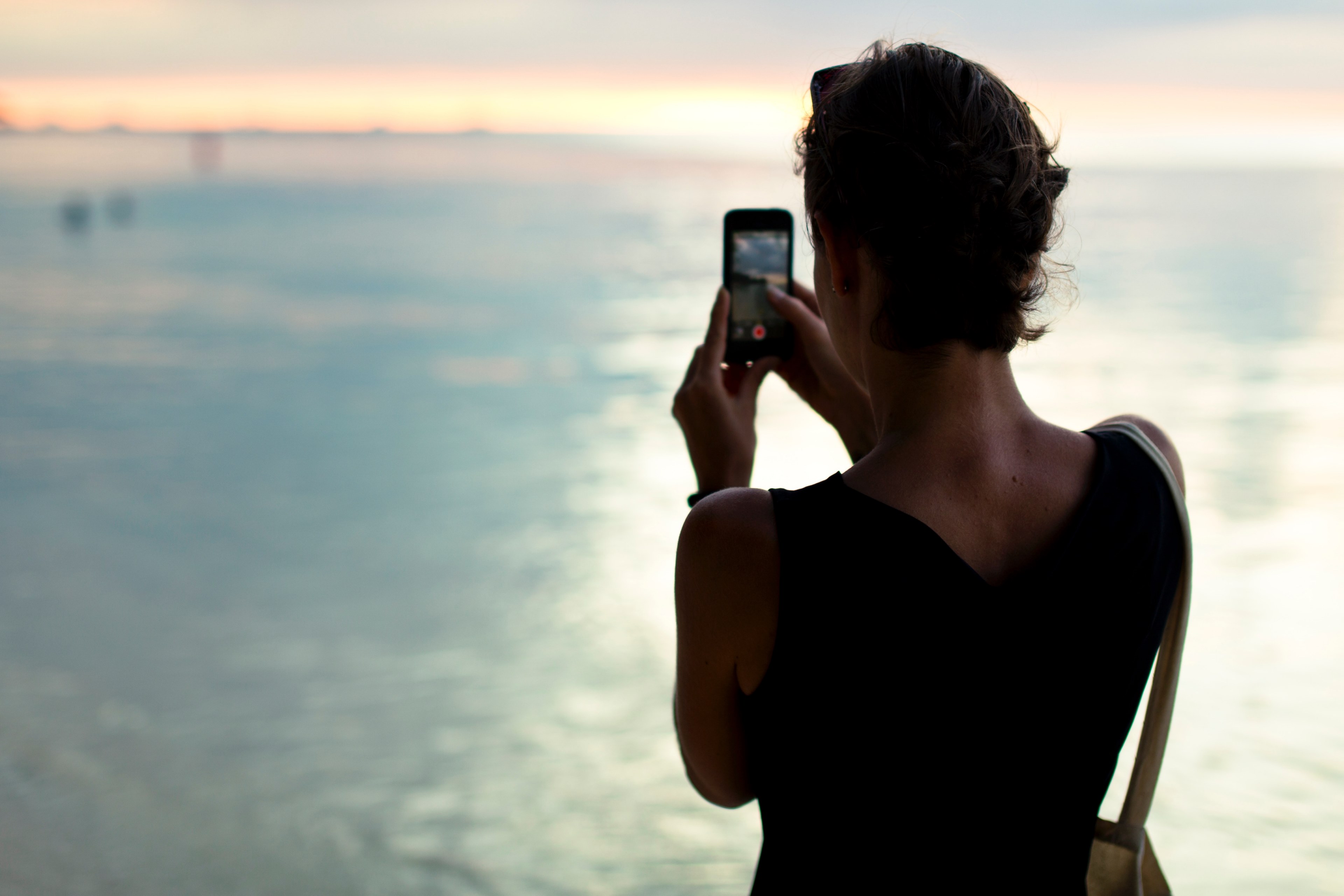 a woman with short hair in a black dress is taking a photo of the sea, _woman dress photo sea 4k, HD Wallpaper