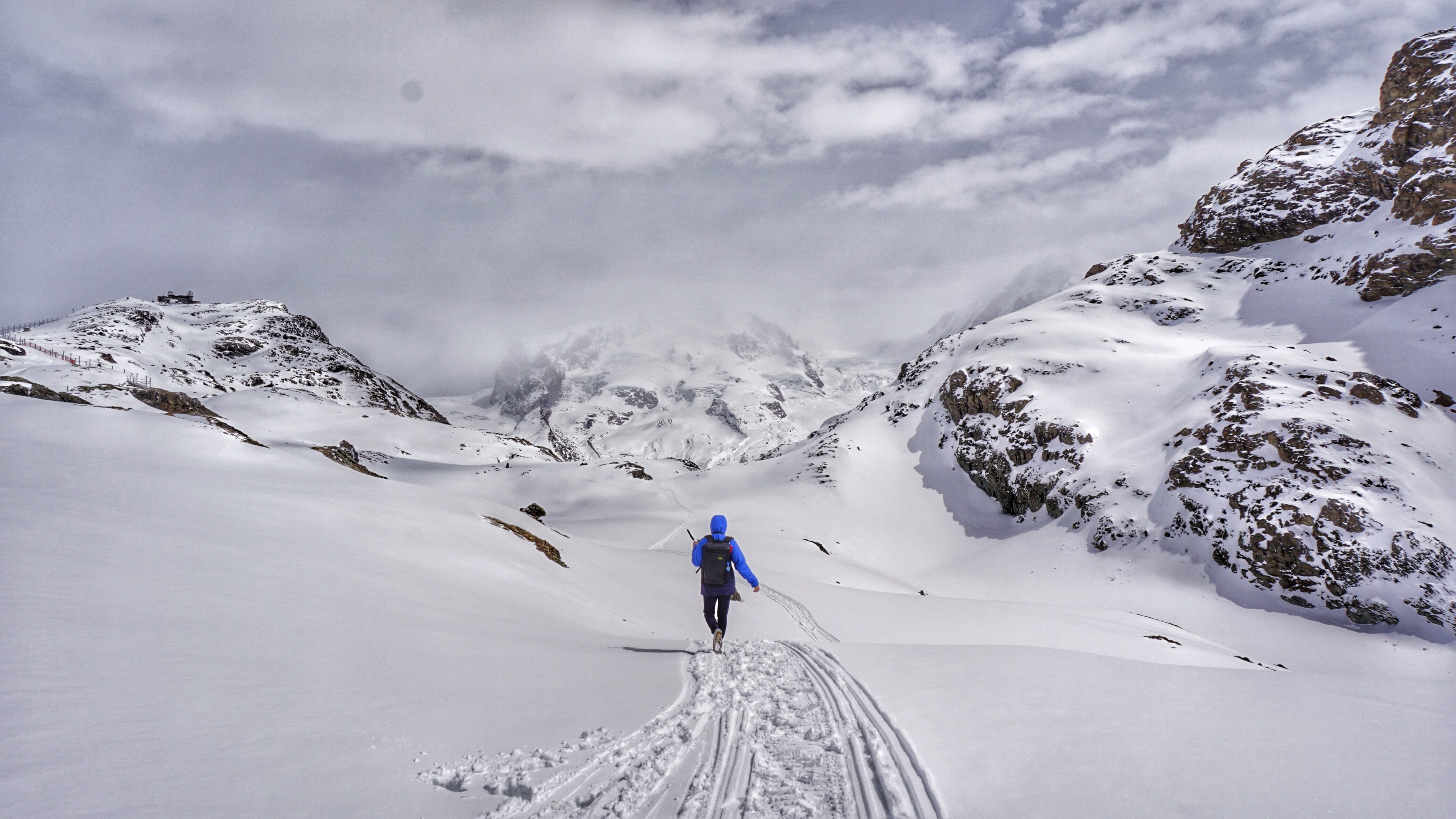 a lone hiker in a blue jacket walks down a mountain in matterhorn glacier park while wearing a backpack, mountain hiker 4k, HD Wallpaper